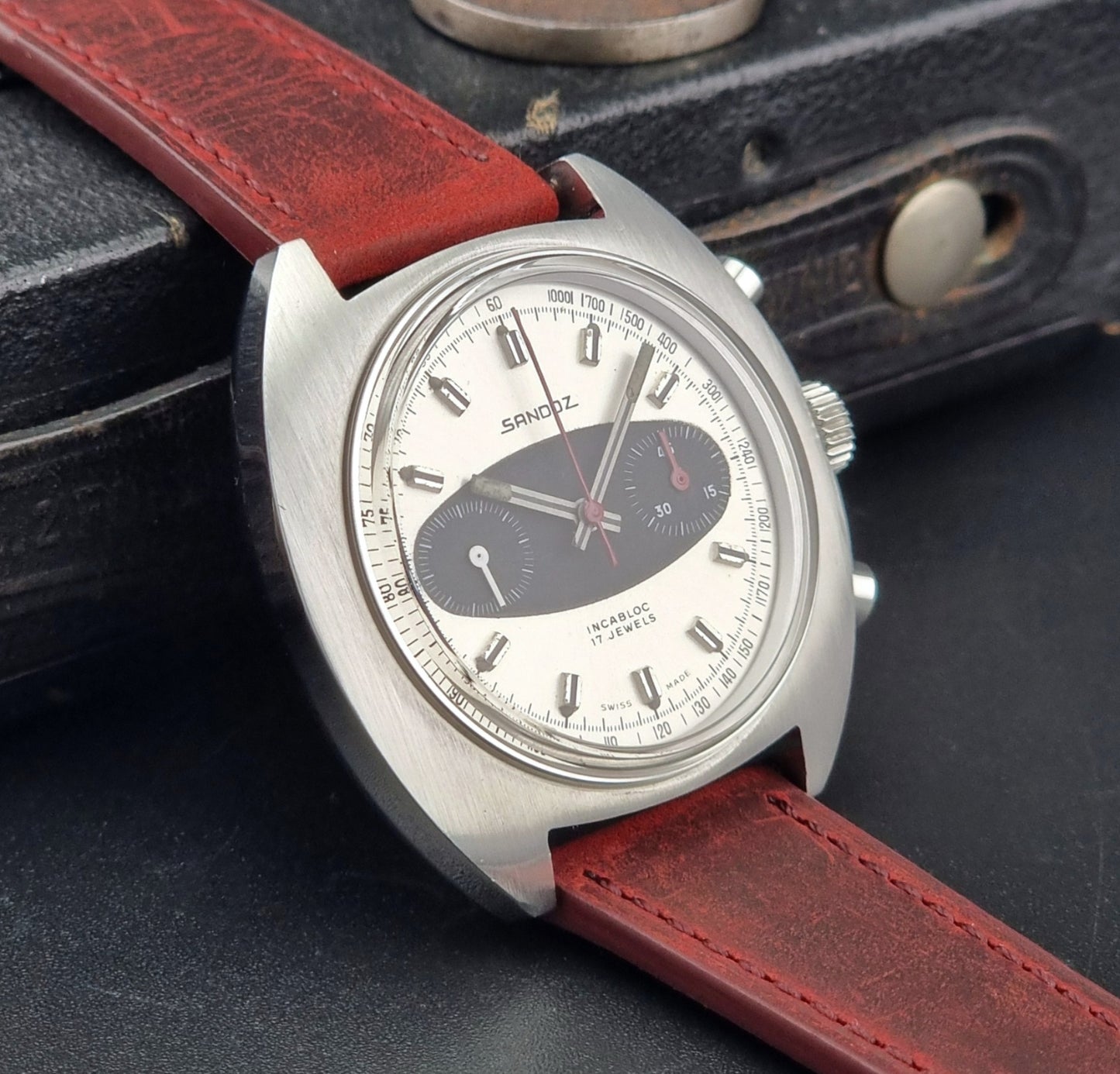 Vintage Sandoz watch watch with red leather strap on a dark textured background
