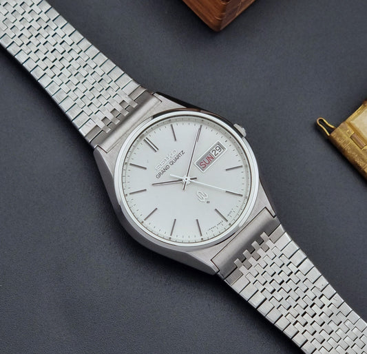 Vintage Grand Quartz watch 4843-8110 with a detailed face on a dark gray background dial