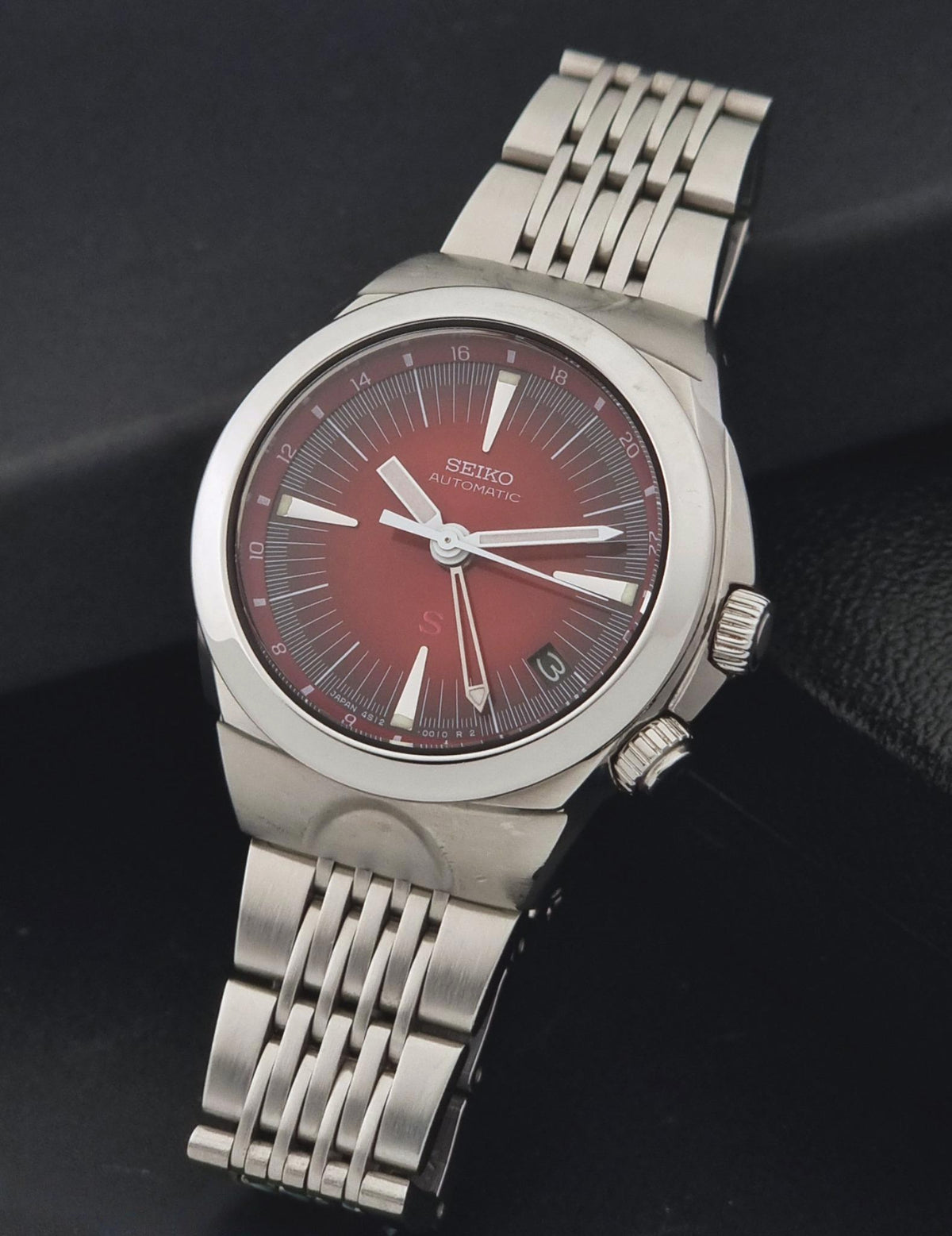 Seiko watch Mechasus SCFF007 GMT 4S12-0010 with a silver-tone stainless steel link bracelet and a dark red dial, shown on a dark textured background.