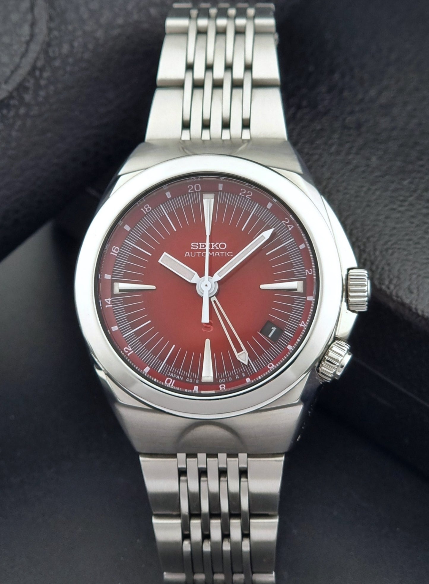 Seiko watch Mechasus SCFF007 GMT 4S12-0010 with a red face on a dark background front view