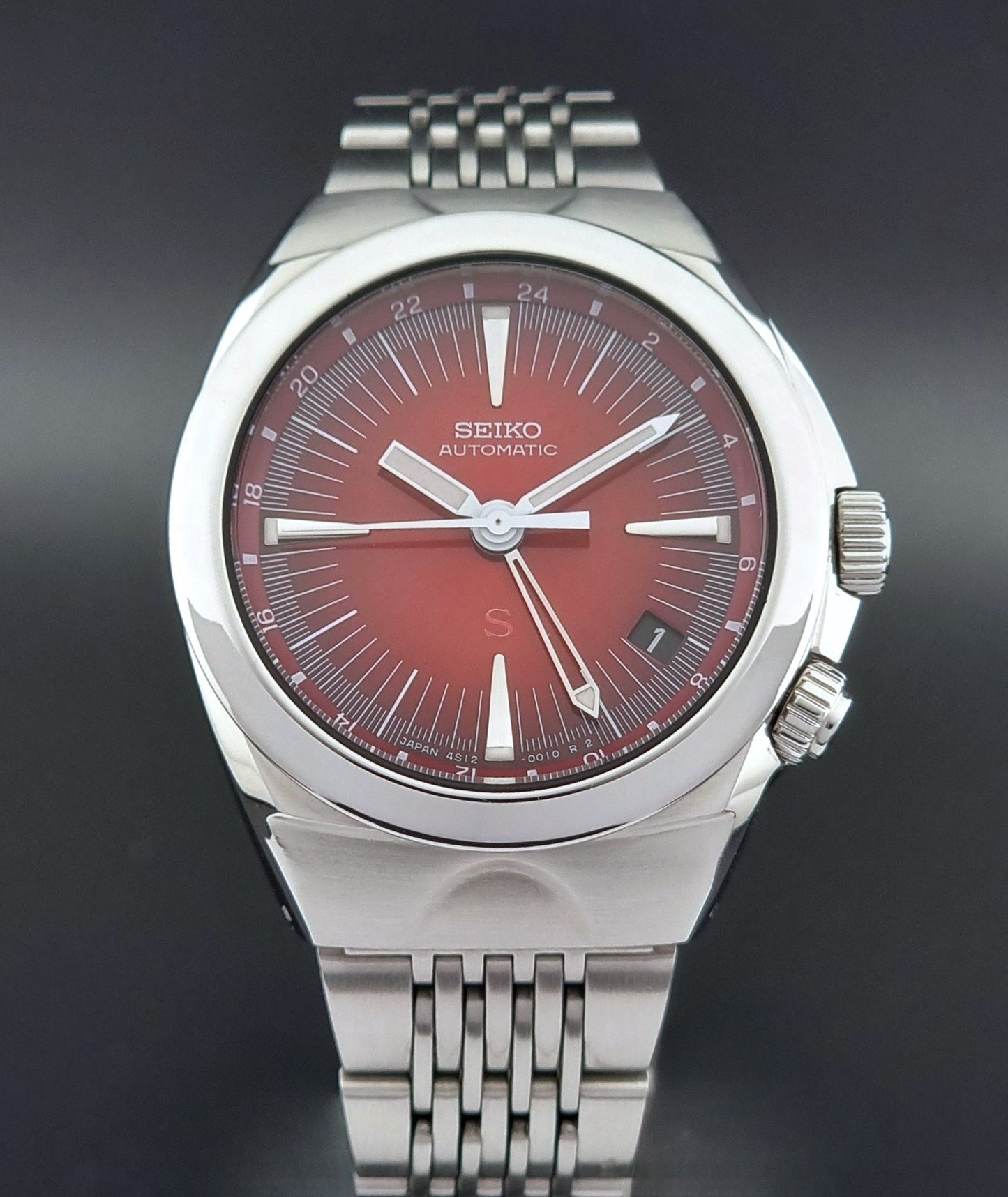 Seiko watch Mechasus SCFF007 GMT 4S12-0010 with a red face on a dark background front close front view