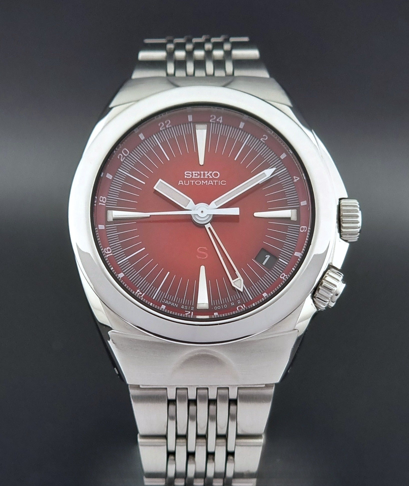 Seiko watch Mechasus SCFF007 GMT 4S12-0010 with a red face on a dark background front close front view