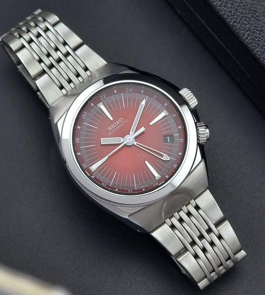 Seiko watch Mechasus SCFF007 GMT 4S12-0010 with a red face on a dark background front