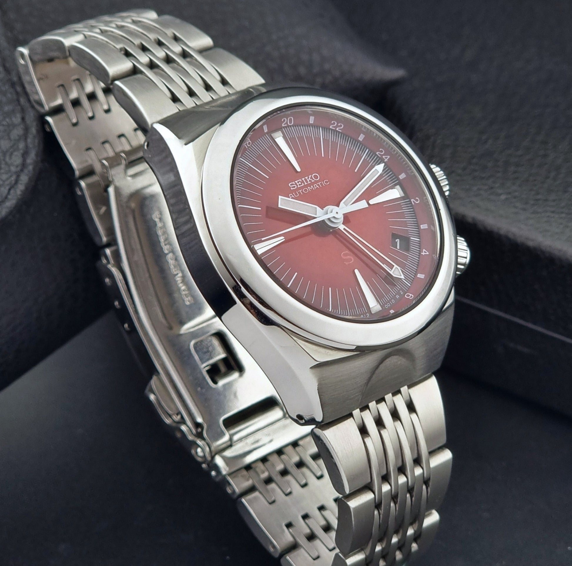 Seiko watch Mechasus SCFF007 GMT 4S12-0010 with a red face on a dark background side view
