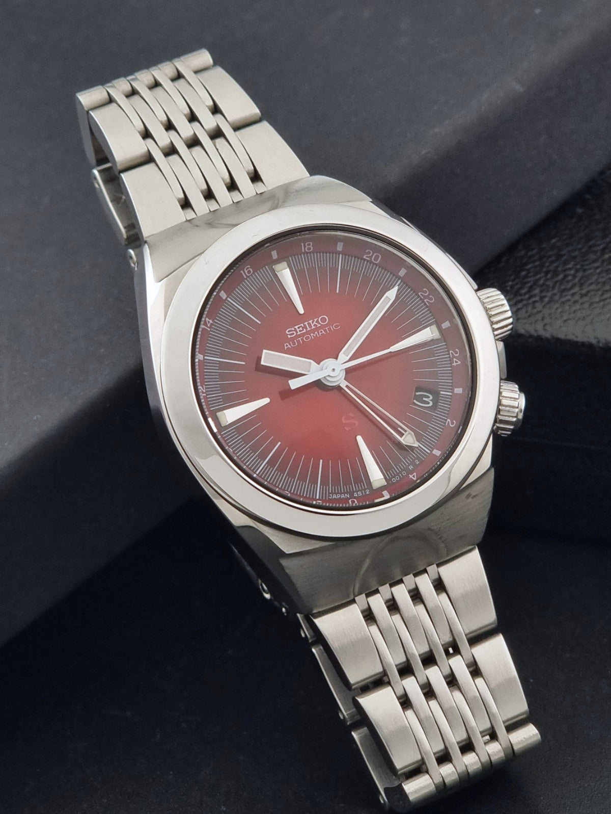Seiko watch Mechasus SCFF007 GMT 4S12-0010 with a silver stainless steel case and link bracelet, featuring a red dial with silver-tone indices and hands.