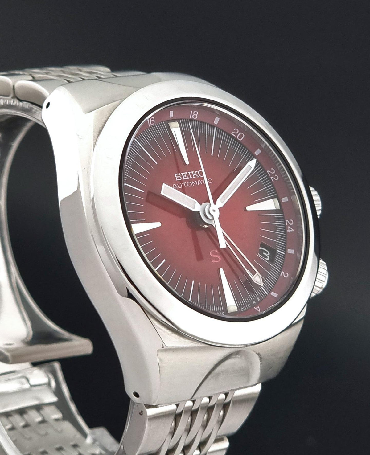 Seiko watch Mechasus SCFF007 GMT 4S12-0010 featuring a silver stainless steel case and bracelet with a deep red dial.