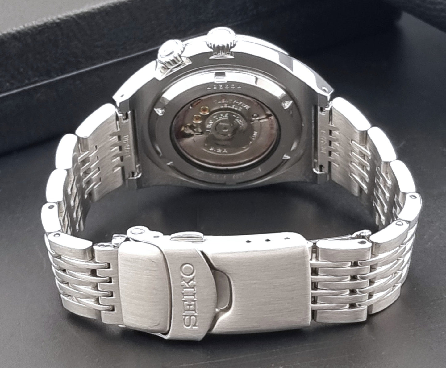Seiko Mechasus SCFF007 GMT 4S12-0010 wristwatch with a red face on a dark background clasp view