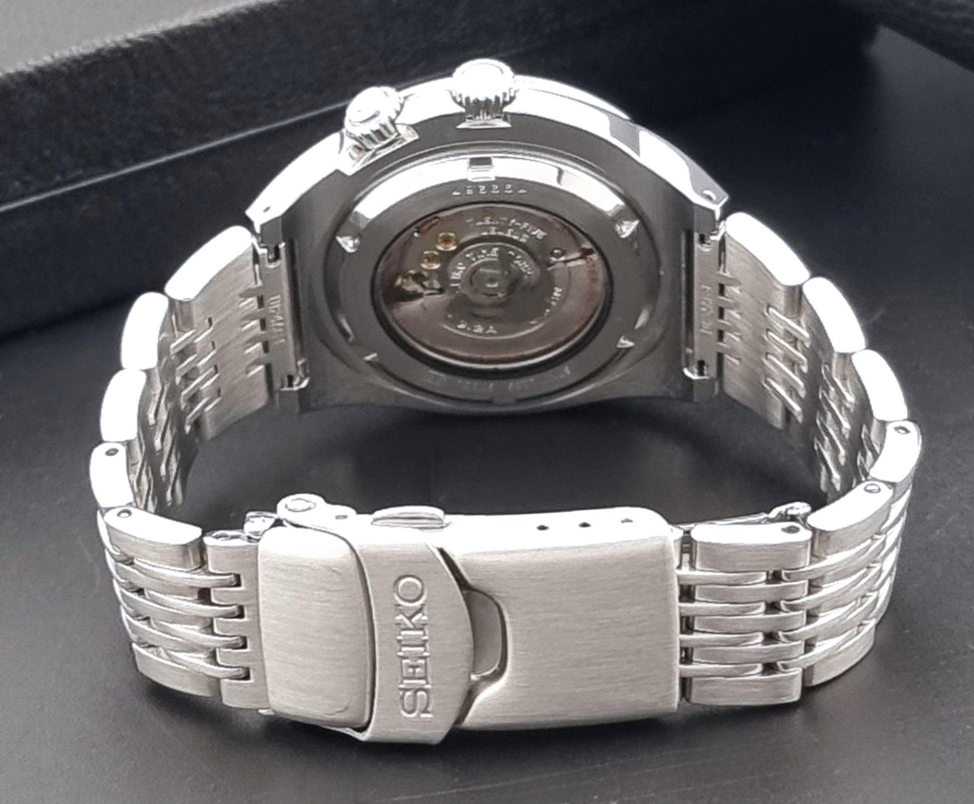 Seiko Mechasus SCFF007 GMT 4S12-0010 wristwatch with a red face on a dark background clasp view