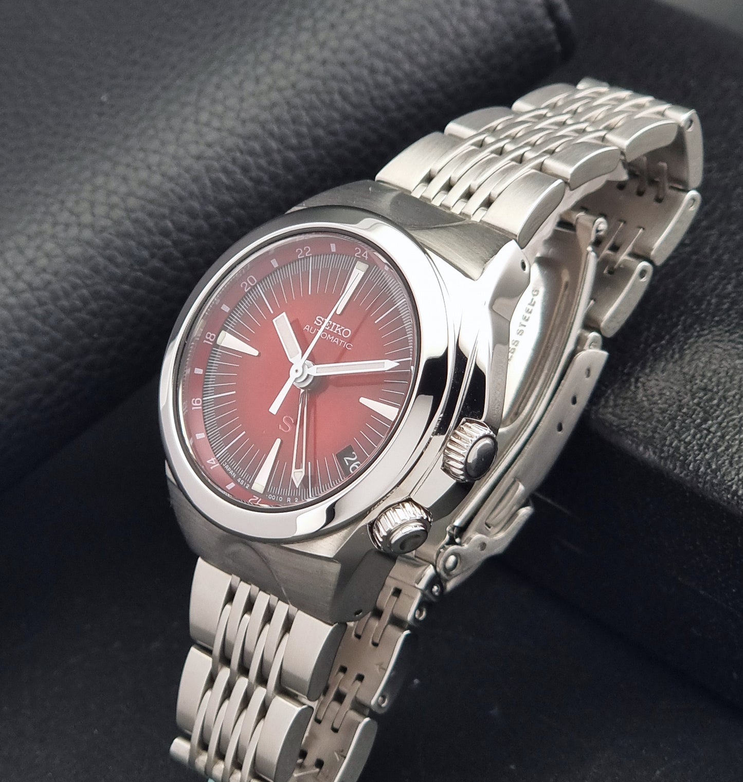 Seiko Mechasus SCFF007 GMT 4S12-0010 wristwatch with a red face on a dark background crown view