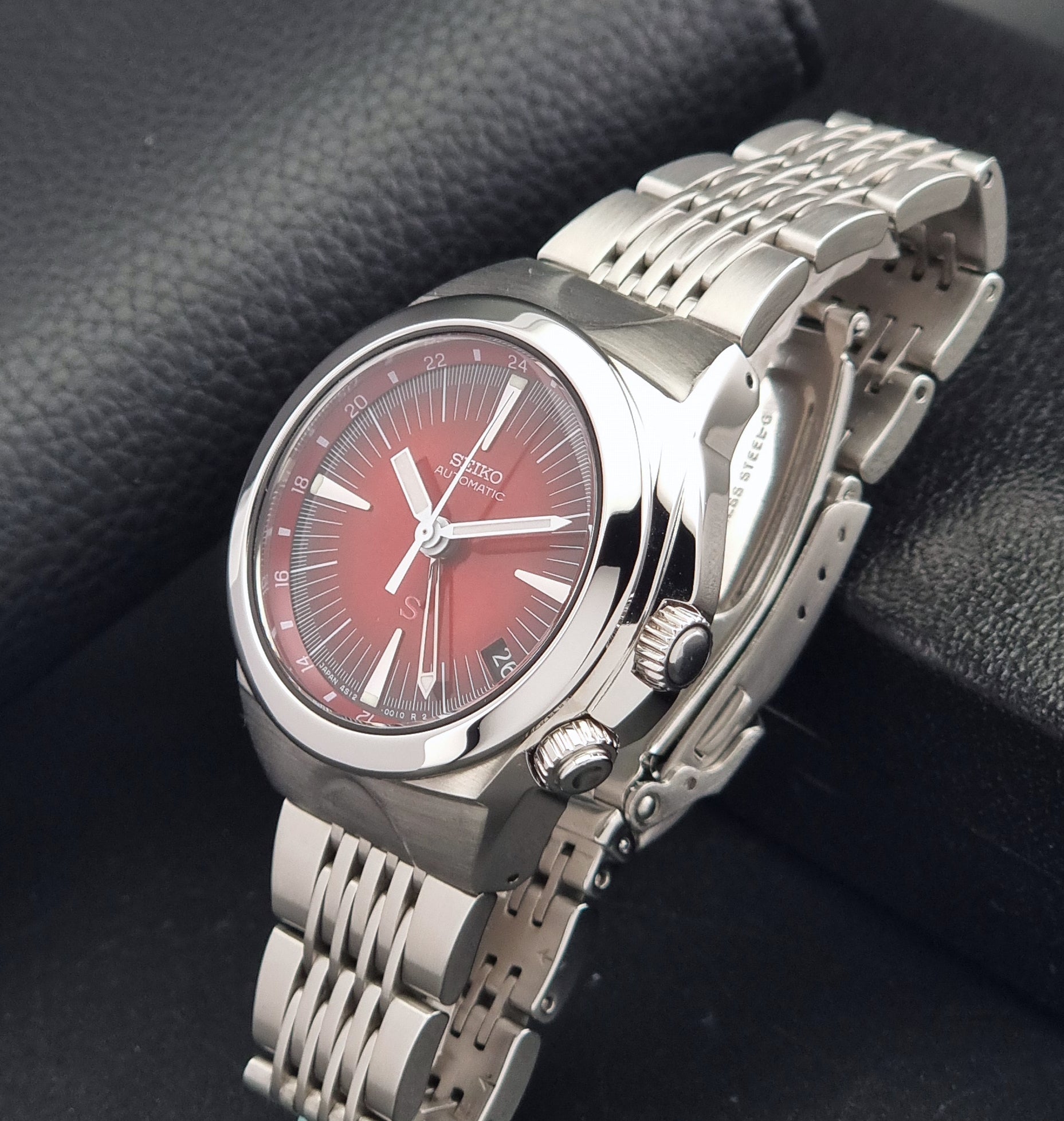 Seiko Mechasus SCFF007 GMT 4S12-0010 wristwatch with a red face on a dark background crown view