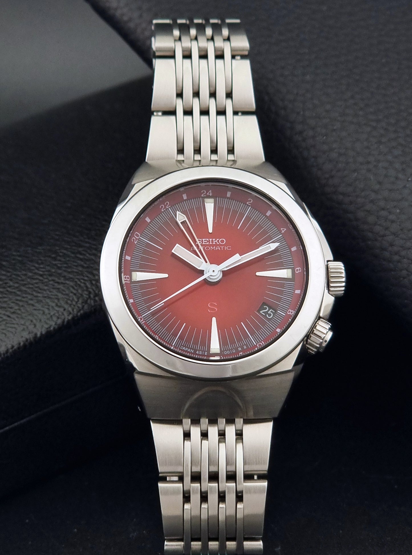 Seiko Mechasus SCFF007 GMT 4S12-0010 wristwatch with a red face on a dark background dial view