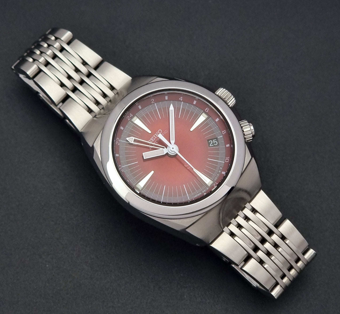 Seiko Mechasus SCFF007 GMT 4S12-0010 wristwatch with a red face on a dark background dial