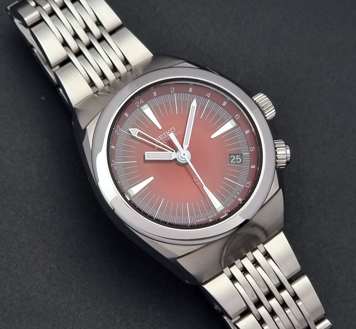 Seiko Mechasus SCFF007 GMT 4S12-0010 wristwatch with a red face on a dark background close up dial view
