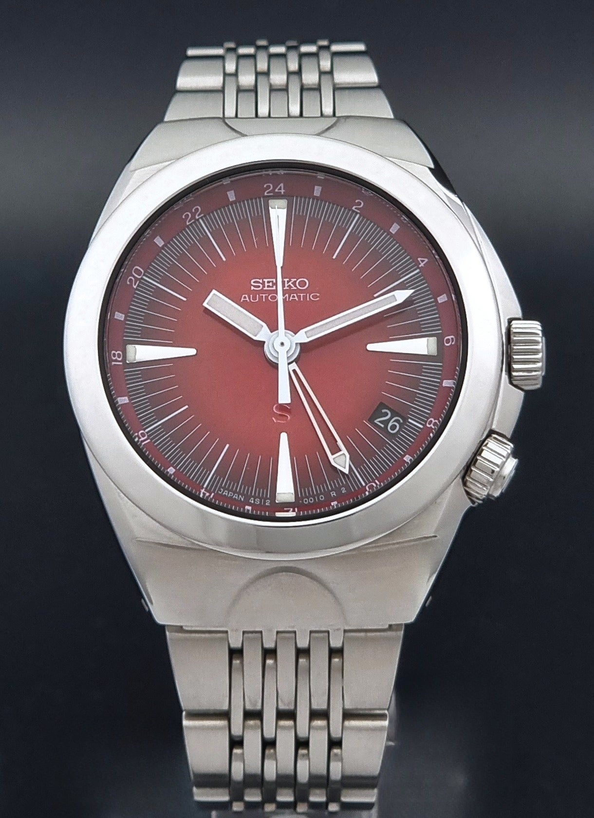 Seiko Mechasus SCFF007 GMT 4S12-0010 wristwatch with a red face on a dark background close dial view