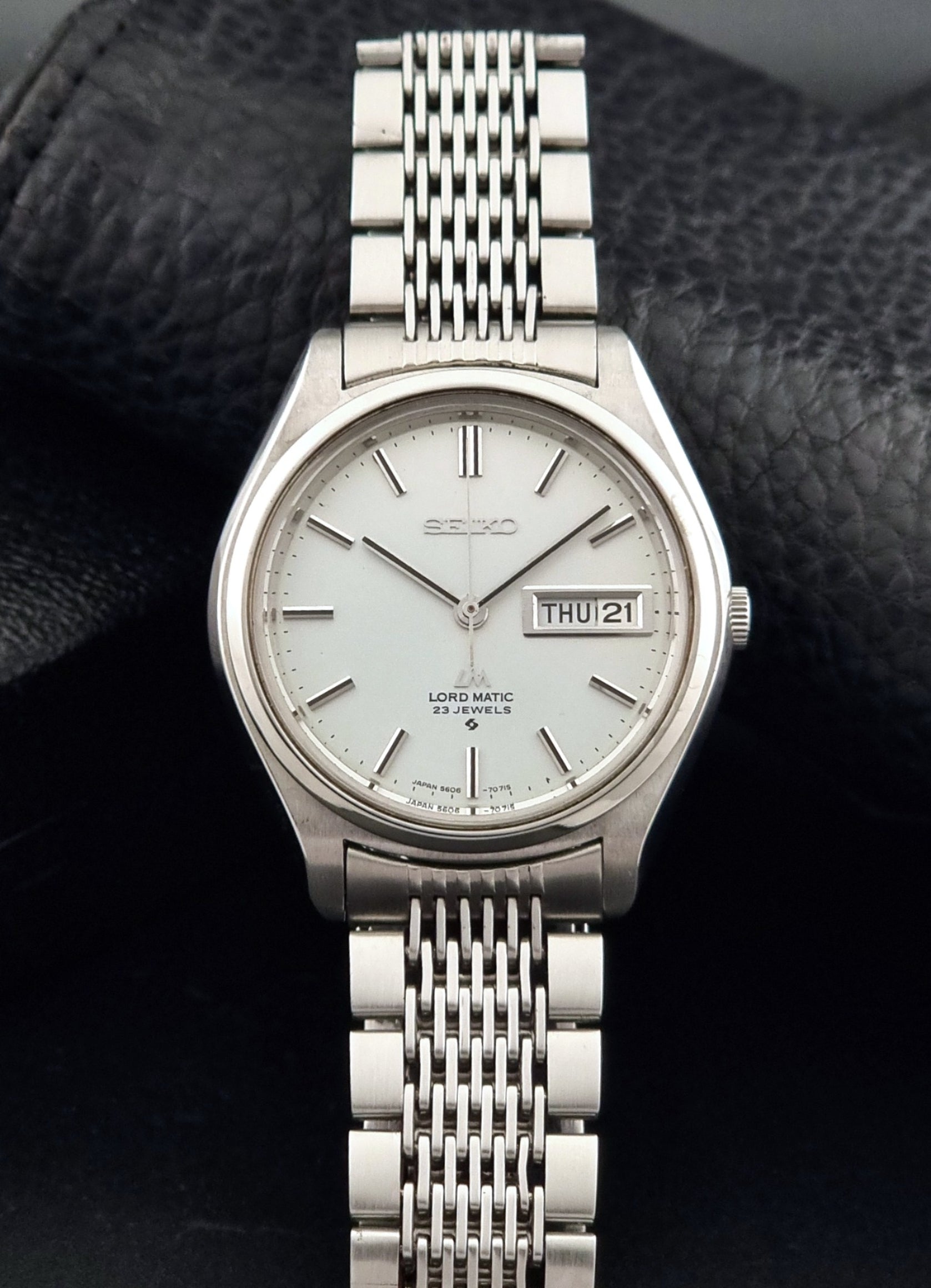 Vintage Seiko 5606-7070 LordMatic with a stainless steel bracelet on a dark background dial view