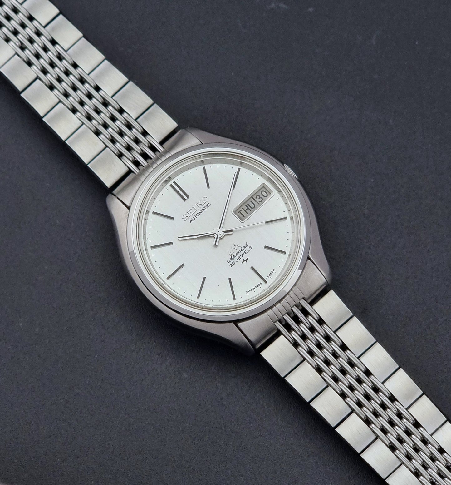 Vintage Seiko watch LordMatic Special 5206-6060 with a white face on a dark gray background dial