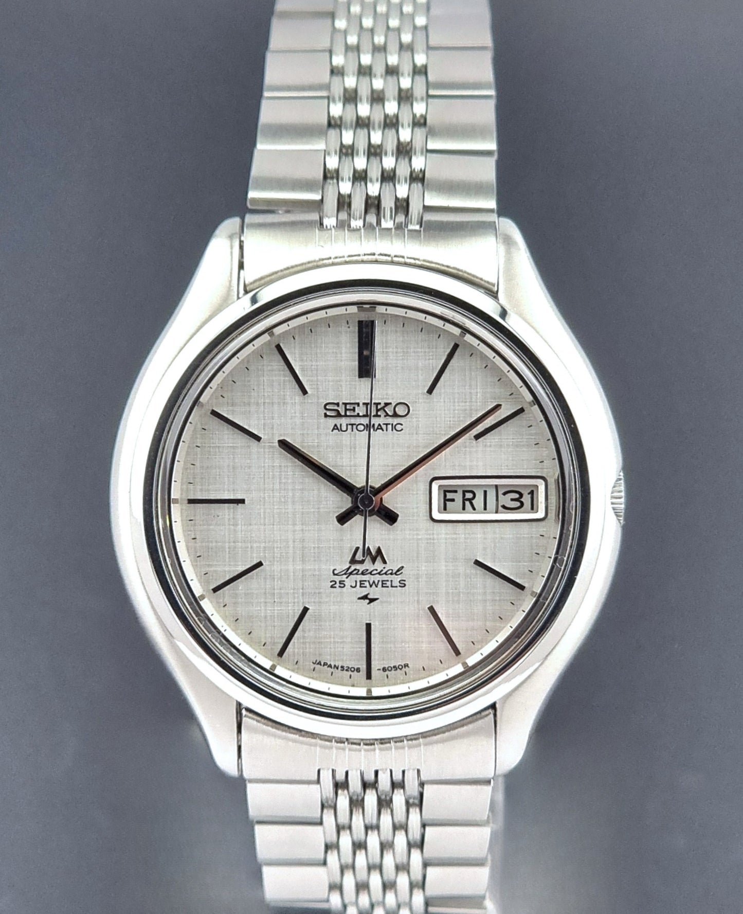 Vintage Seiko watch LordMatic Special 5206-6060 with a white face on a dark gray background close dial view