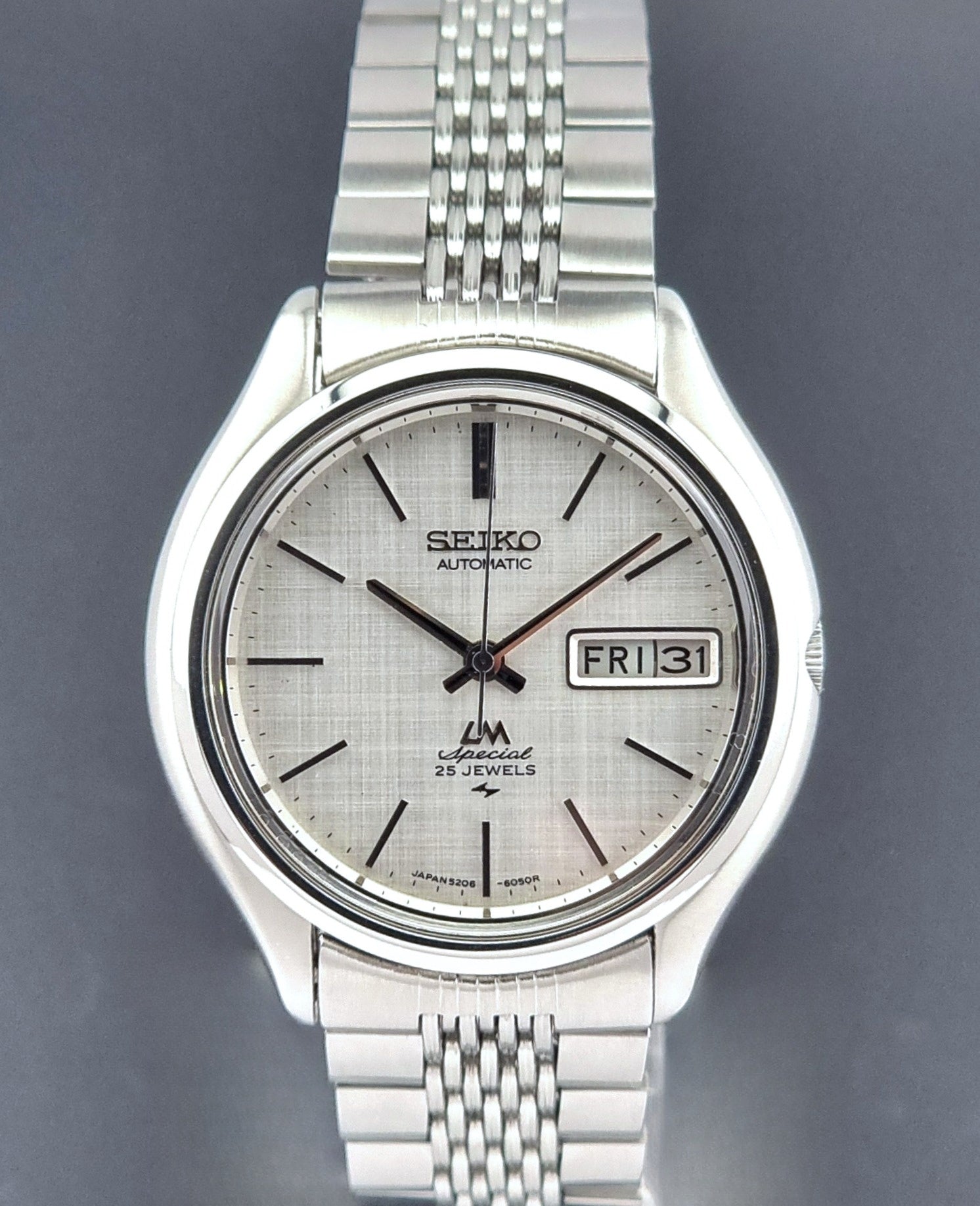 Vintage Seiko watch LordMatic Special 5206-6060 with a white face on a dark gray background close dial view