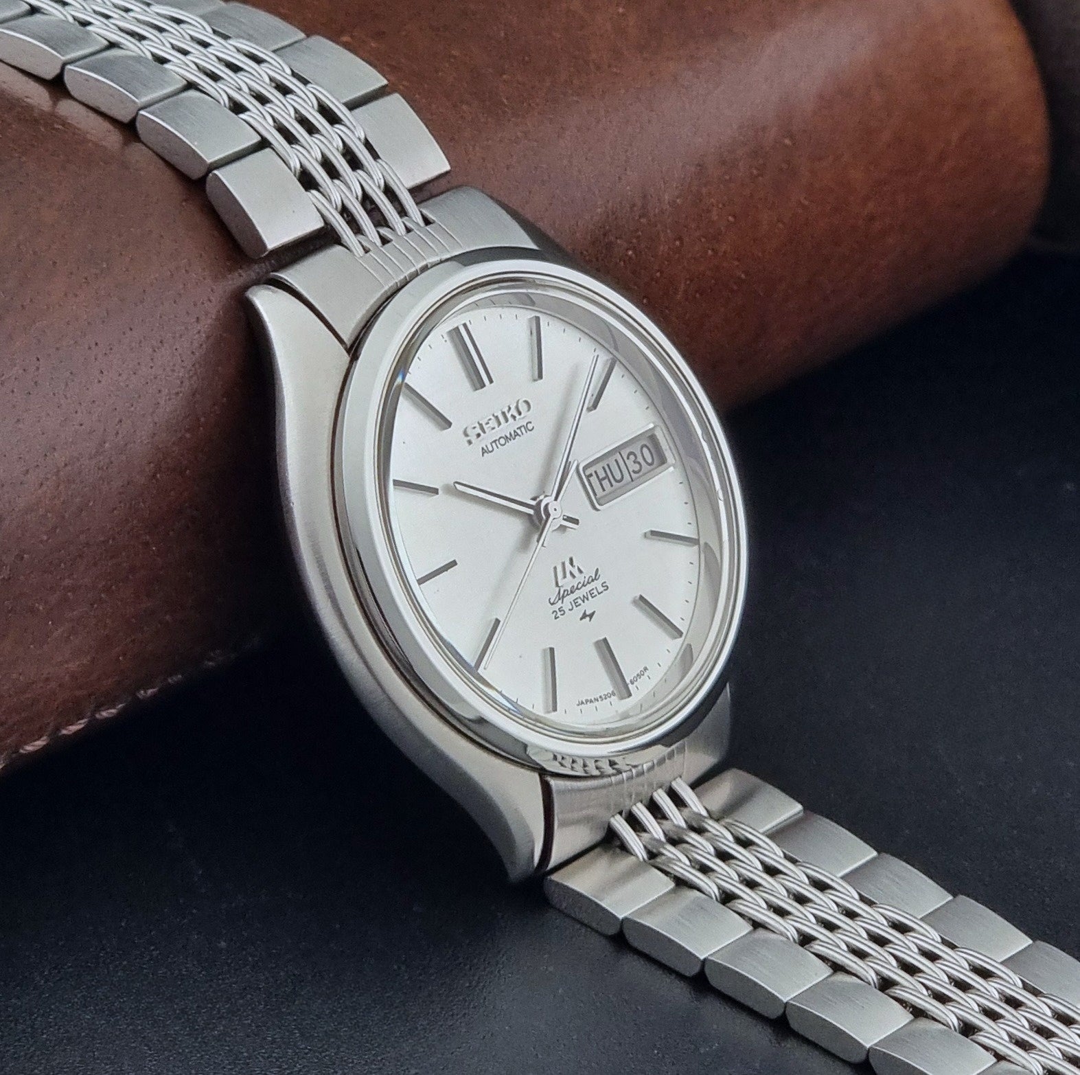 Vintage Seiko watch LordMatic Special 5206-6060 with a white face on a dark gray background side view