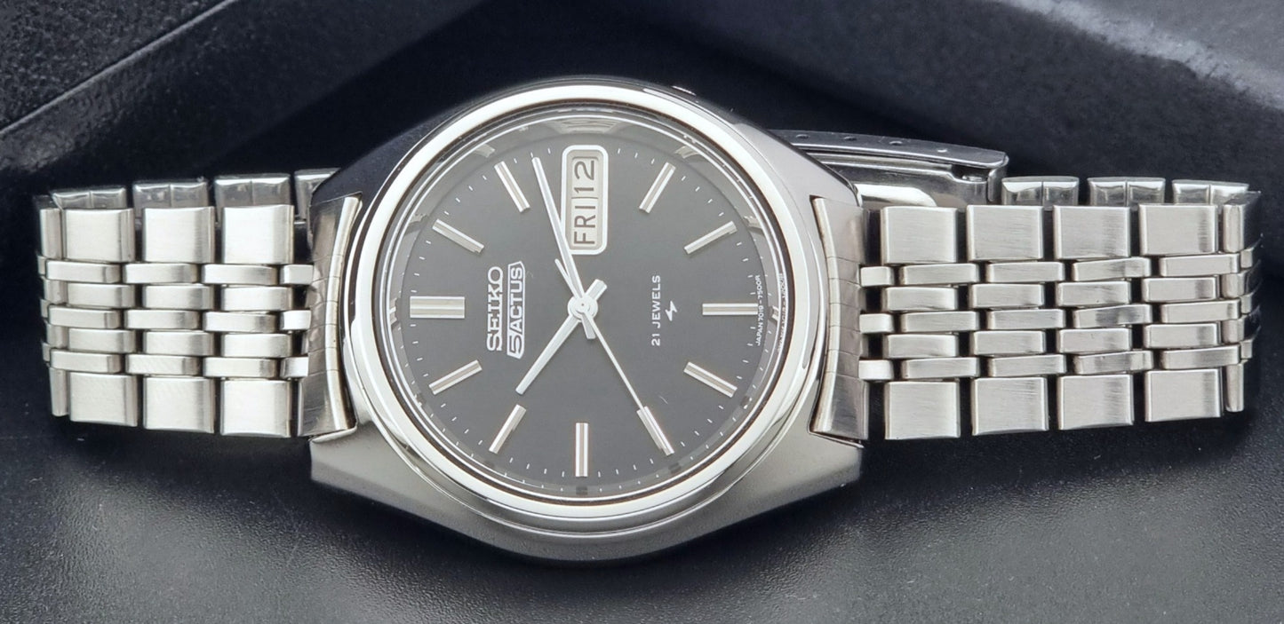 Vintage Seiko 5 Actus Wristwatch 7019-7060 with a stainless steel bracelet on a dark surface close up dial view