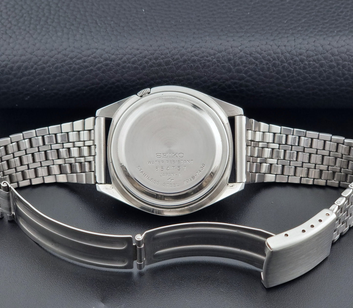 Vintage Seiko Actus Wristwatch 7019-7430 with a blue dial and bracelet on a dark back ground clasp view