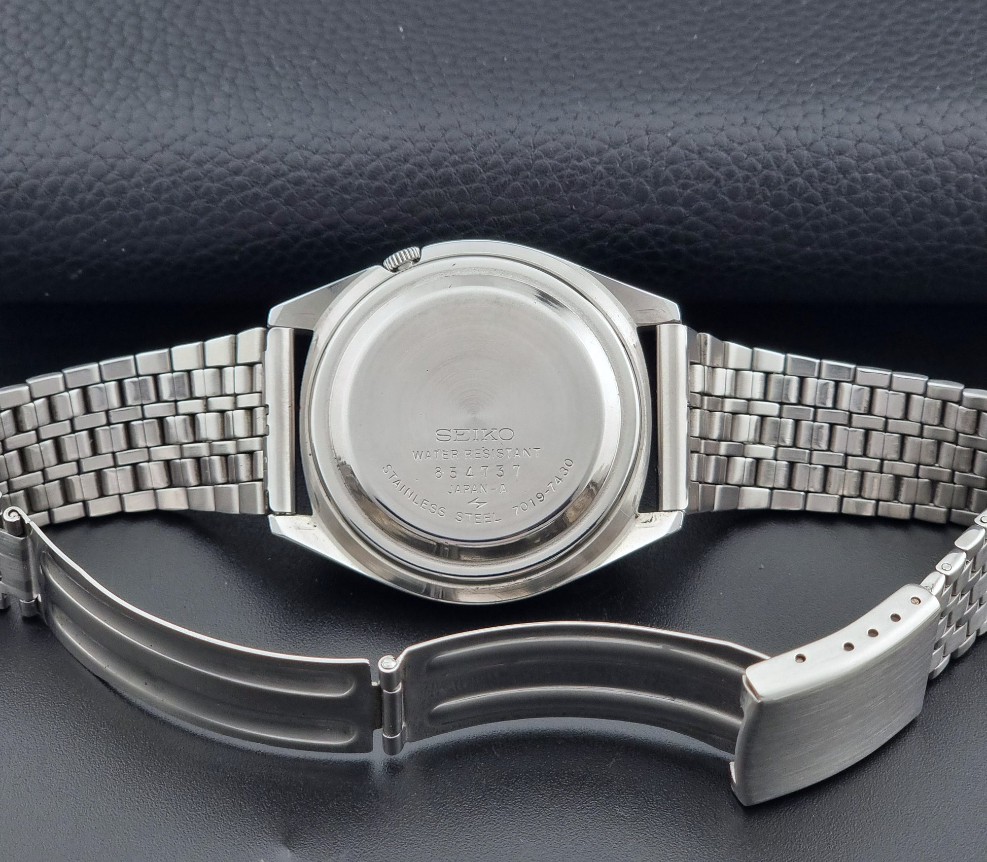 Vintage Seiko Actus Wristwatch 7019-7430 with a blue dial and bracelet on a dark back ground clasp view