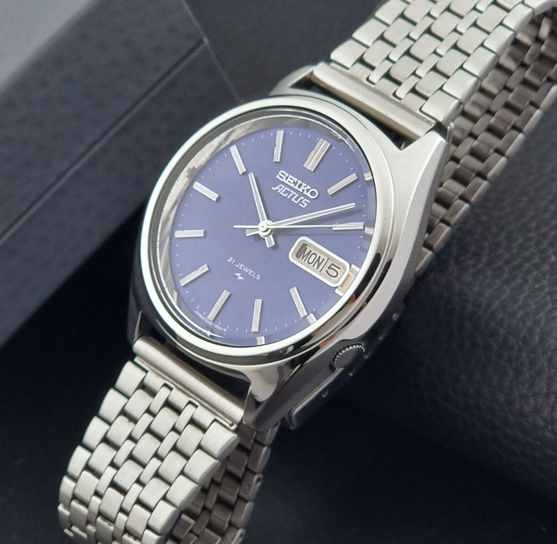 Vintage Seiko Actus Wristwatch 7019-7430 with a blue dial and bracelet on a dark back ground crown view