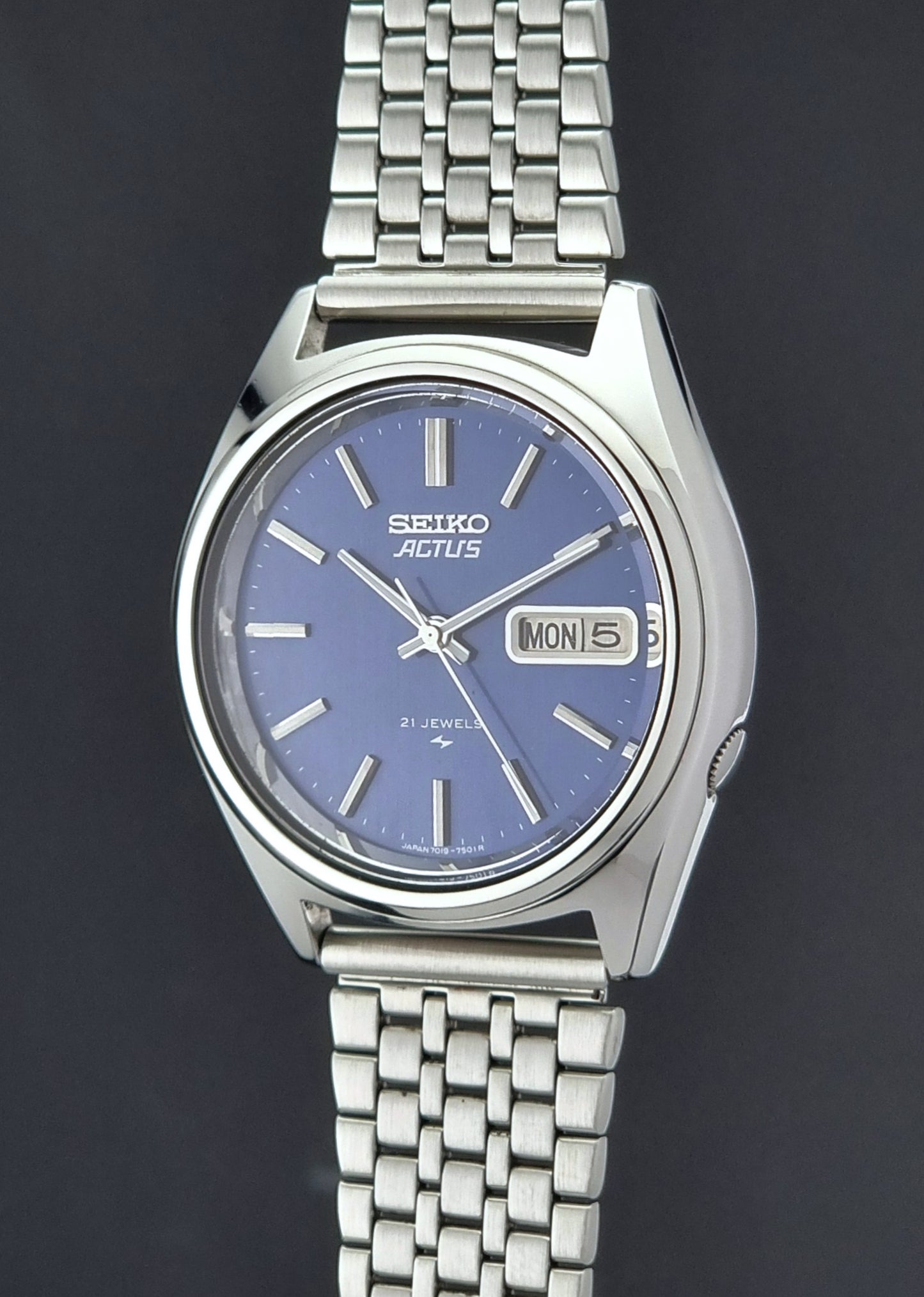 Vintage Seiko Actus Wristwatch 7019-7430 with a blue dial and bracelet on a dark back ground crown profile view