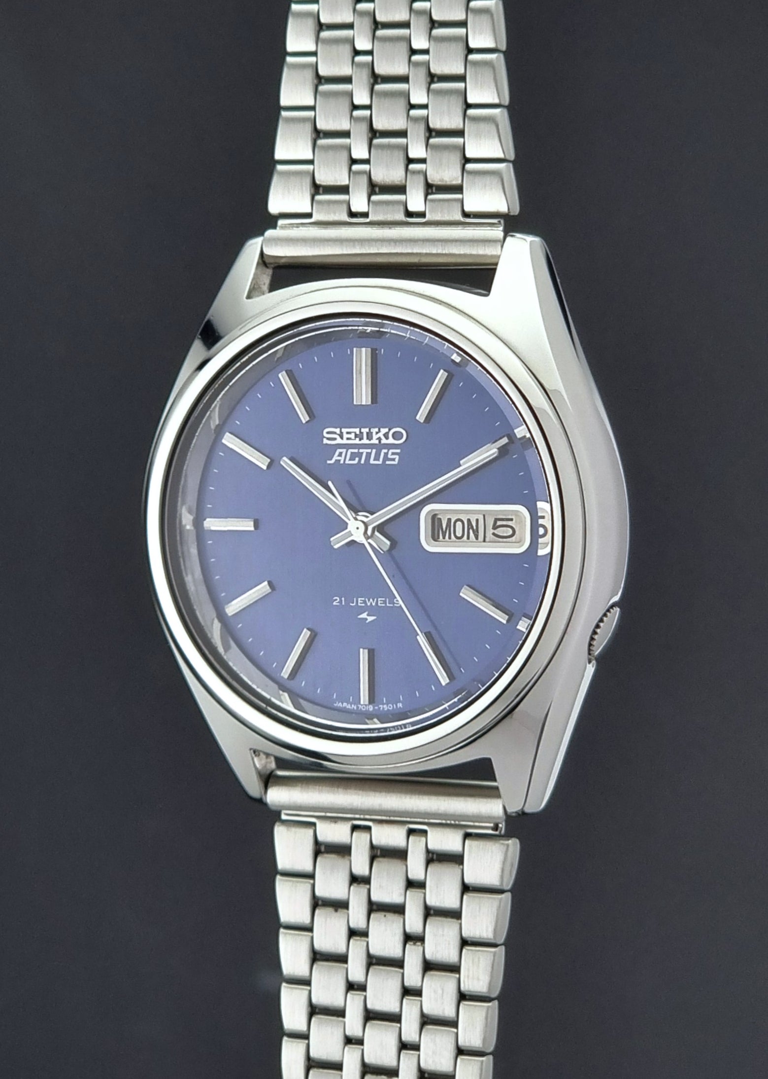 Vintage Seiko Actus Wristwatch 7019-7430 with a blue dial and bracelet on a dark back ground crown profile view