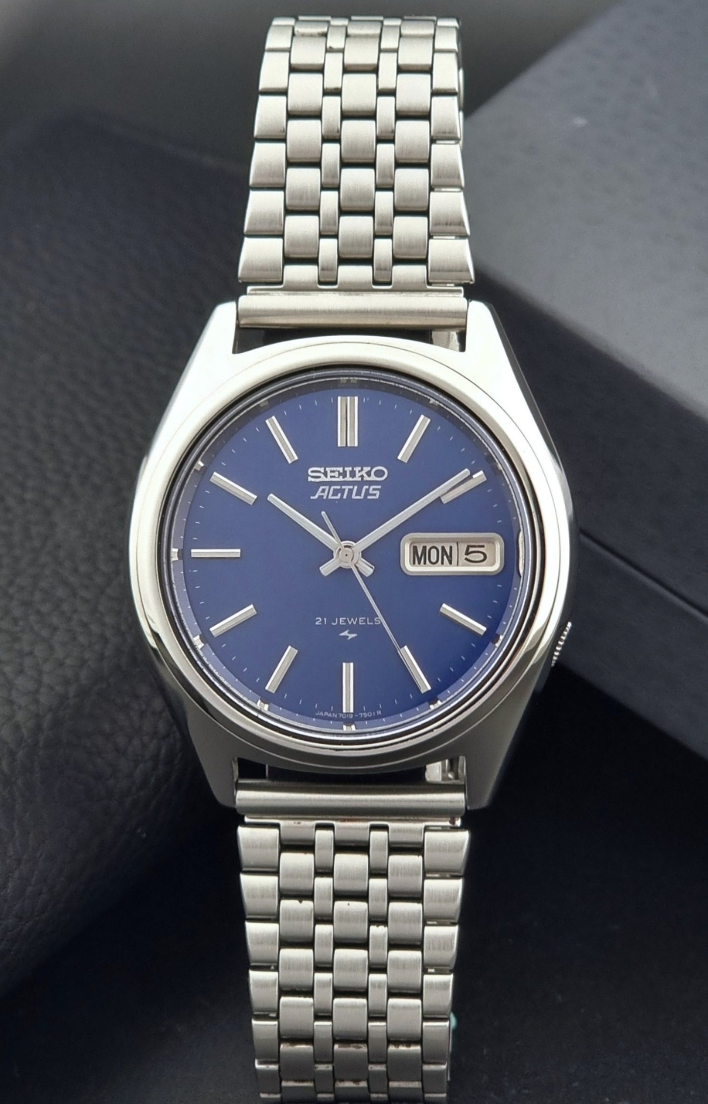 Vintage Seiko Actus Wristwatch 7019-7430 with a blue dial and bracelet on a dark back ground dial view