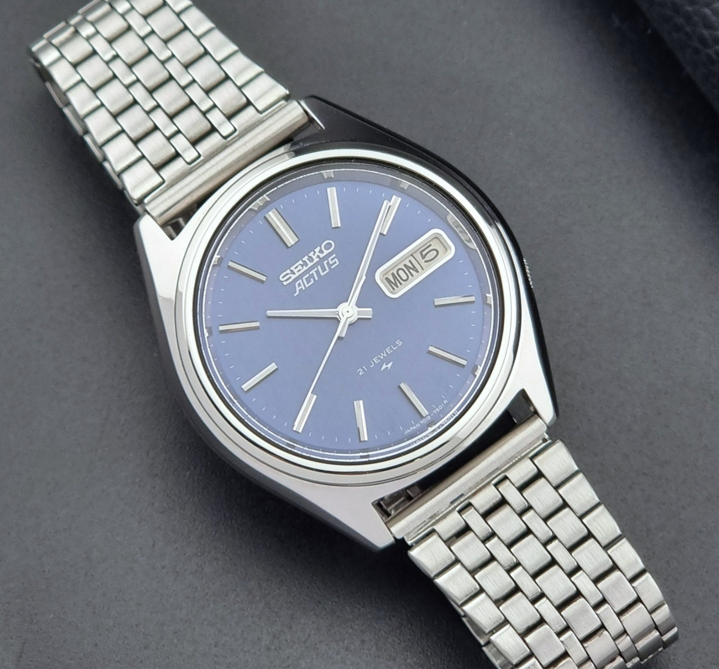 Vintage Seiko Actus Wristwatch 7019-7430 with a blue dial and bracelet on a dark back ground close up dial view