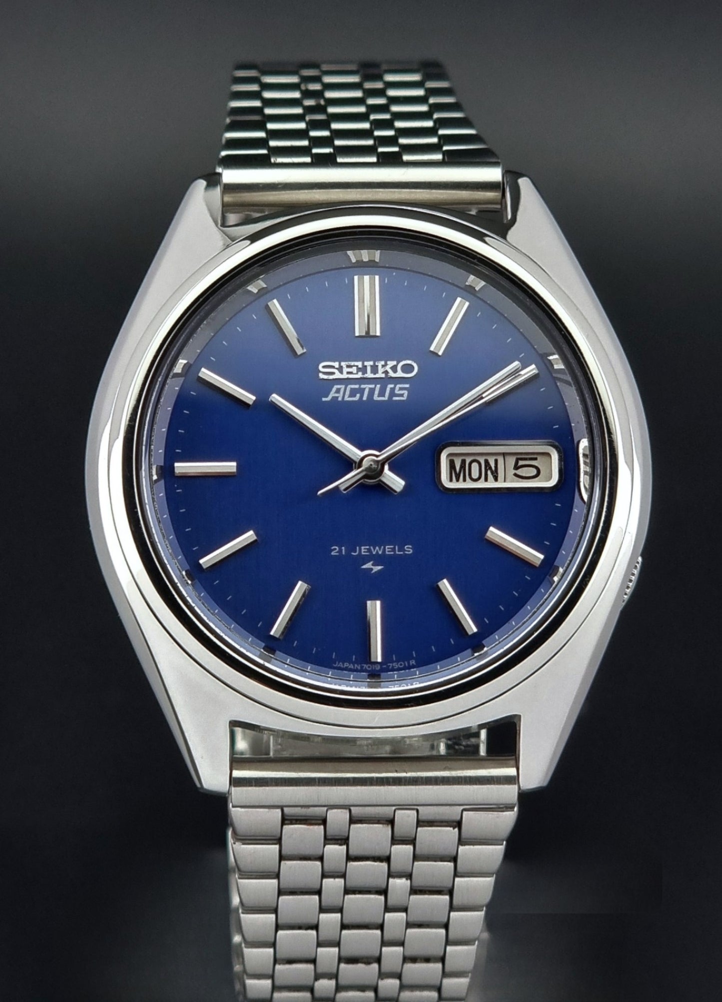 Vintage Seiko Actus Wristwatch 7019-7430 with a blue dial and bracelet on a dark back ground close dial view