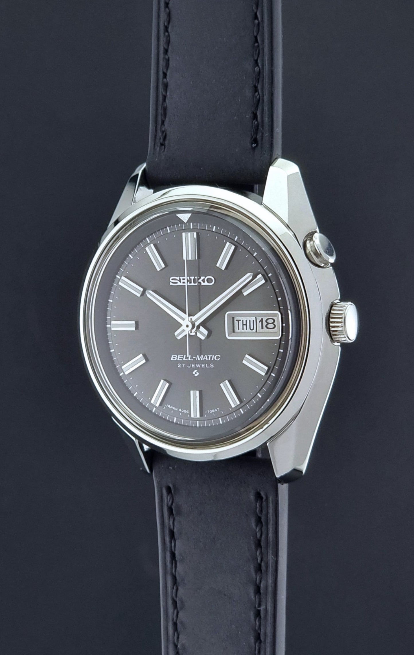 Vintage Seiko Bell-matic Wristwatch with black leather strap on a dark  background crown profile
