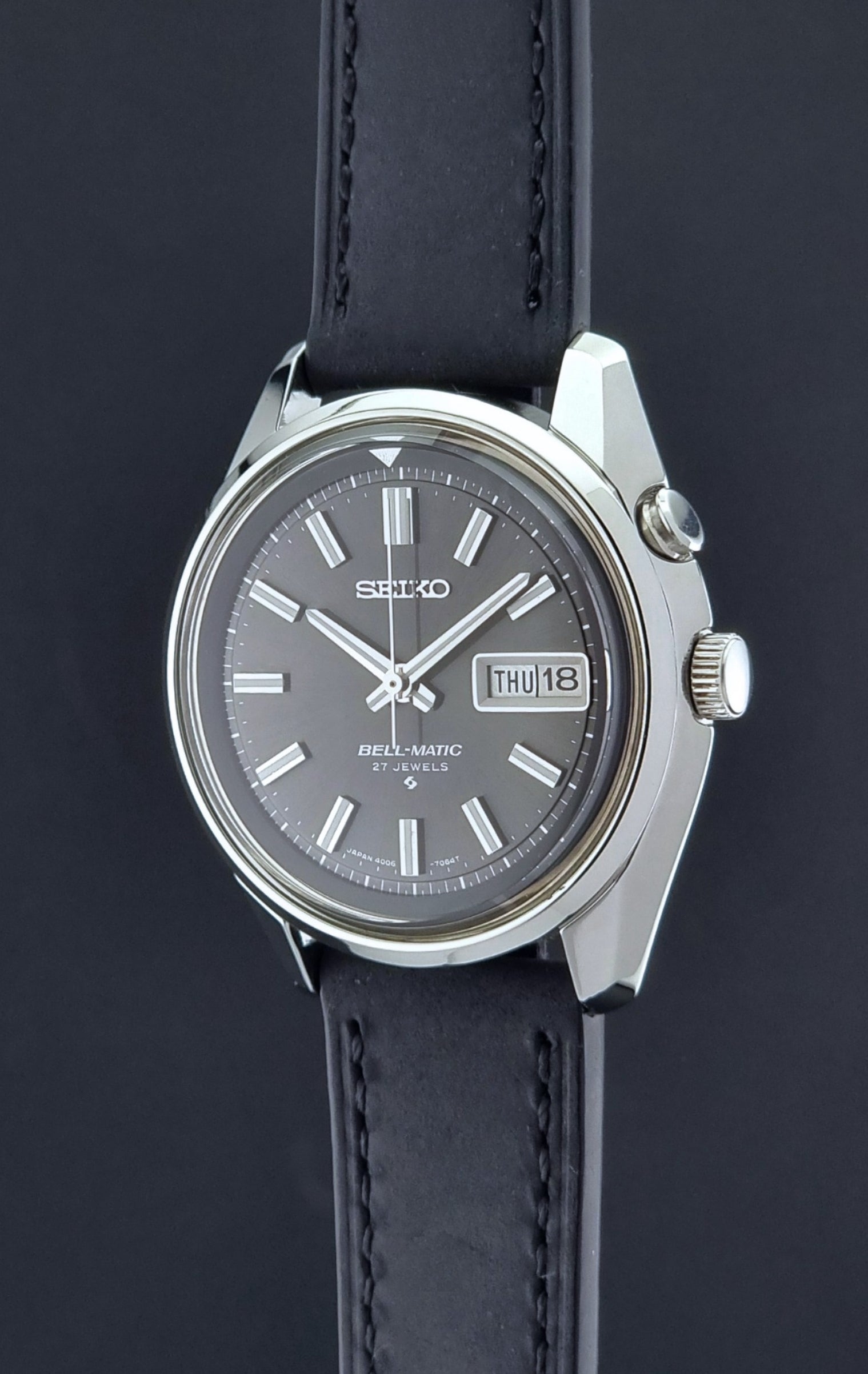 Vintage Seiko Bell-matic Wristwatch with black leather strap on a dark  background crown profile