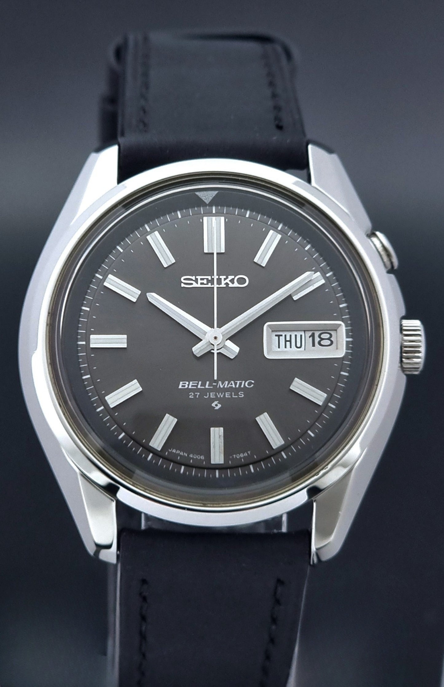 Vintage Seiko Bell-matic Wristwatch with black leather strap on a dark background dial view