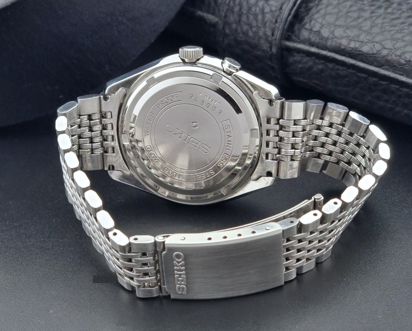 Vintage Seiko Alarm Watch Bell-Matic 4006-7010 with a dark face on a black background bracelet view
