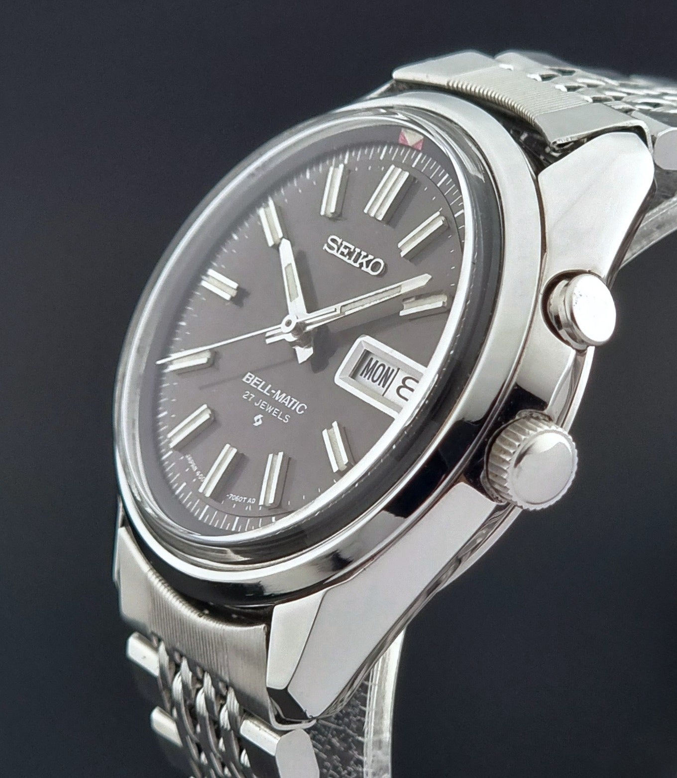 Vintage Seiko Alarm Watch Bell-Matic 4006-7010 with a dark face on a black background close crown profile view