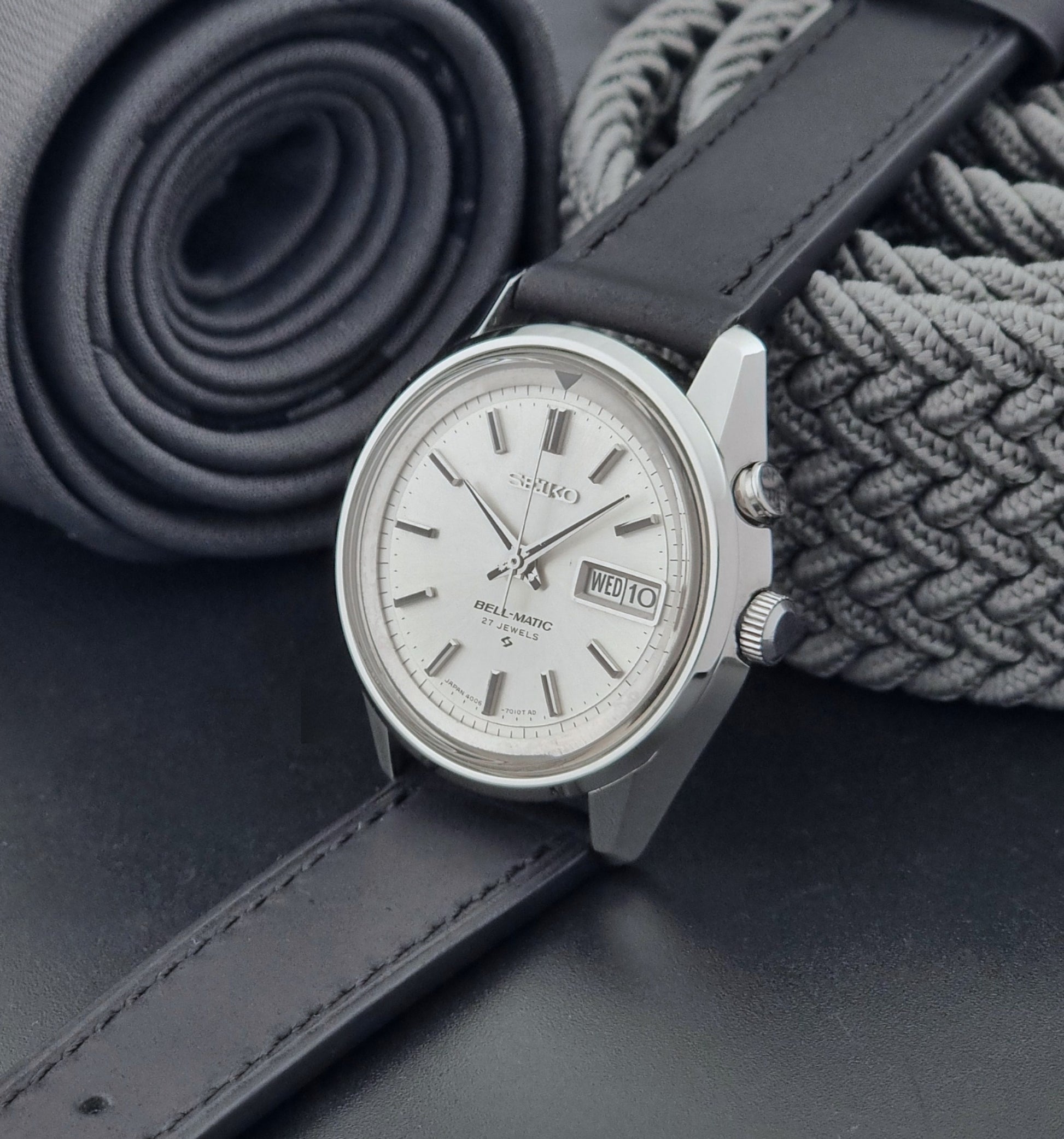 Vintage Seiko Alarm Wristwatch Bell-Matic 4006-7010 with black leather strap on a dark surface crown view