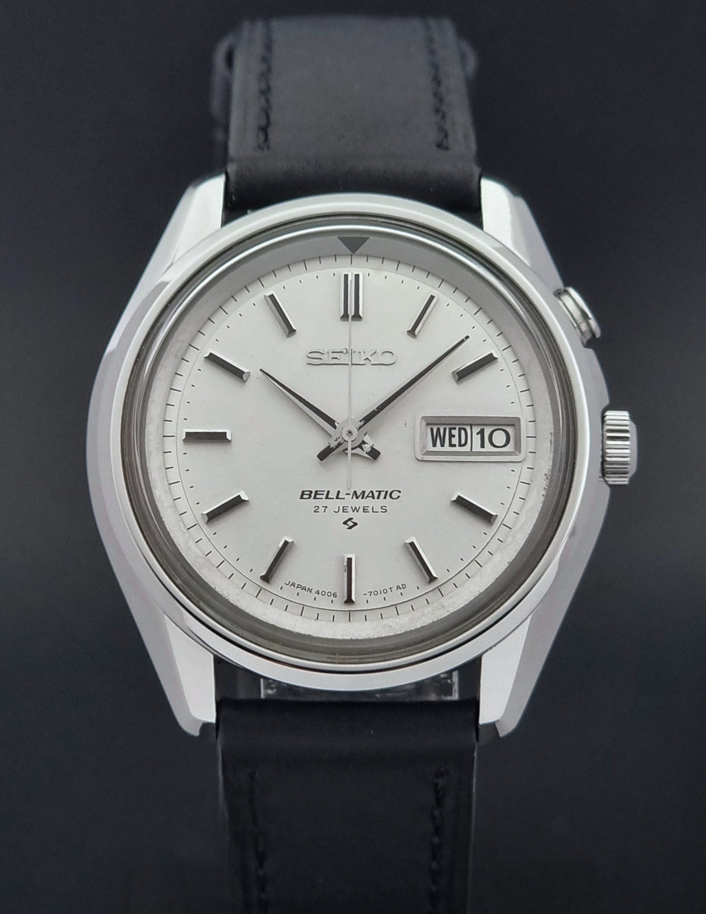 Vintage Seiko Alarm Wristwatch Bell-Matic 4006-7010 with black leather strap on a dark surface close dial view