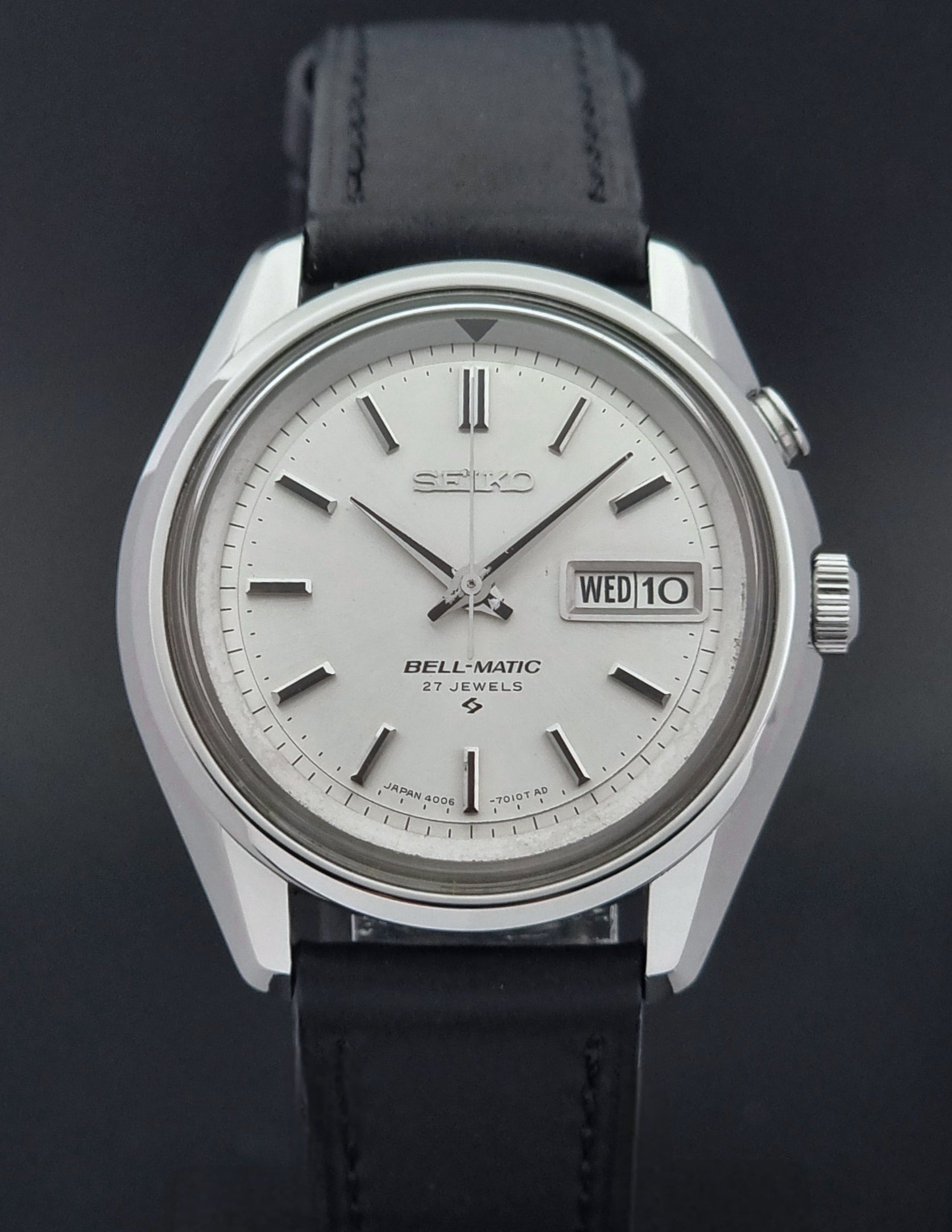 Vintage Seiko Alarm Wristwatch Bell-Matic 4006-7010 with black leather strap on a dark surface close dial view