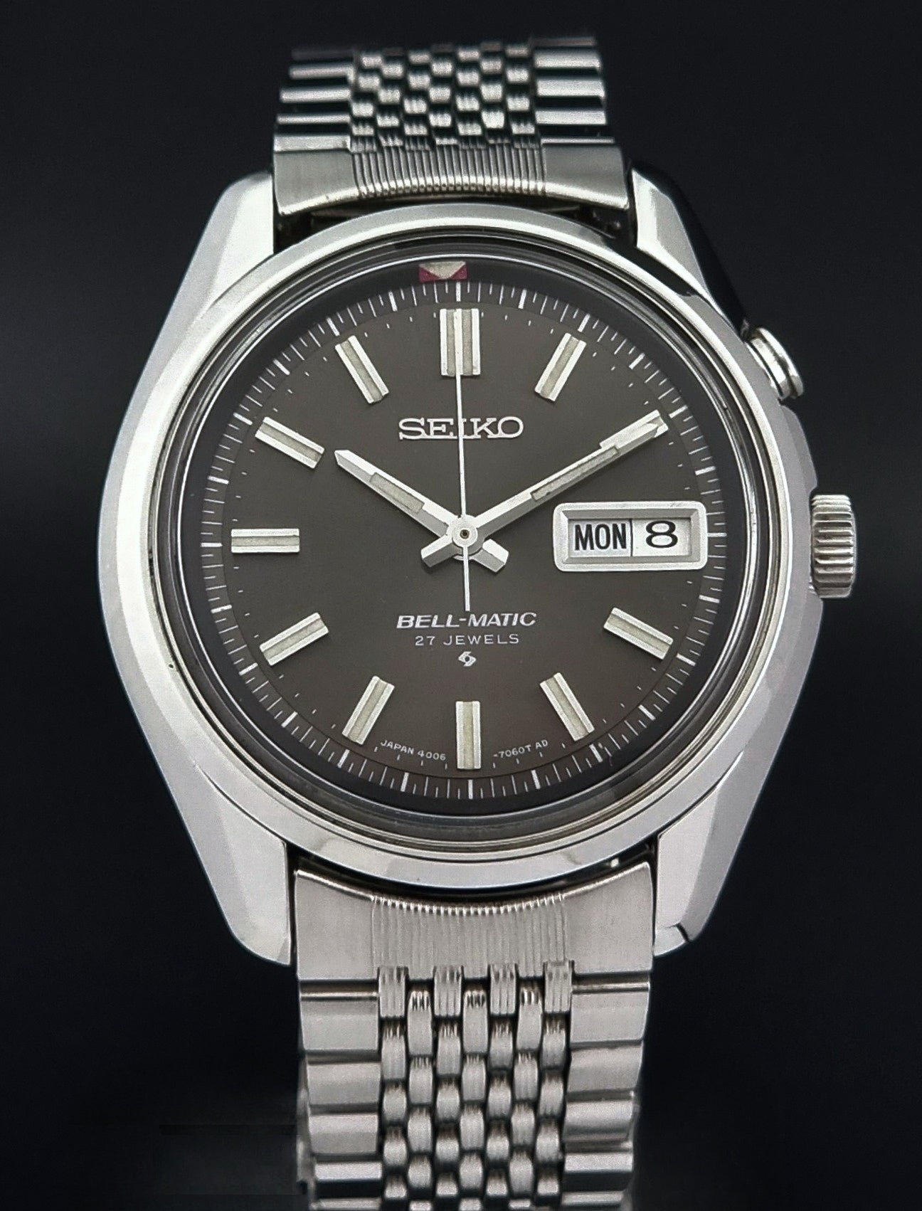 Vintage Seiko Alarm Watch Bell-Matic 4006-7010 with a dark face on a black background close front view