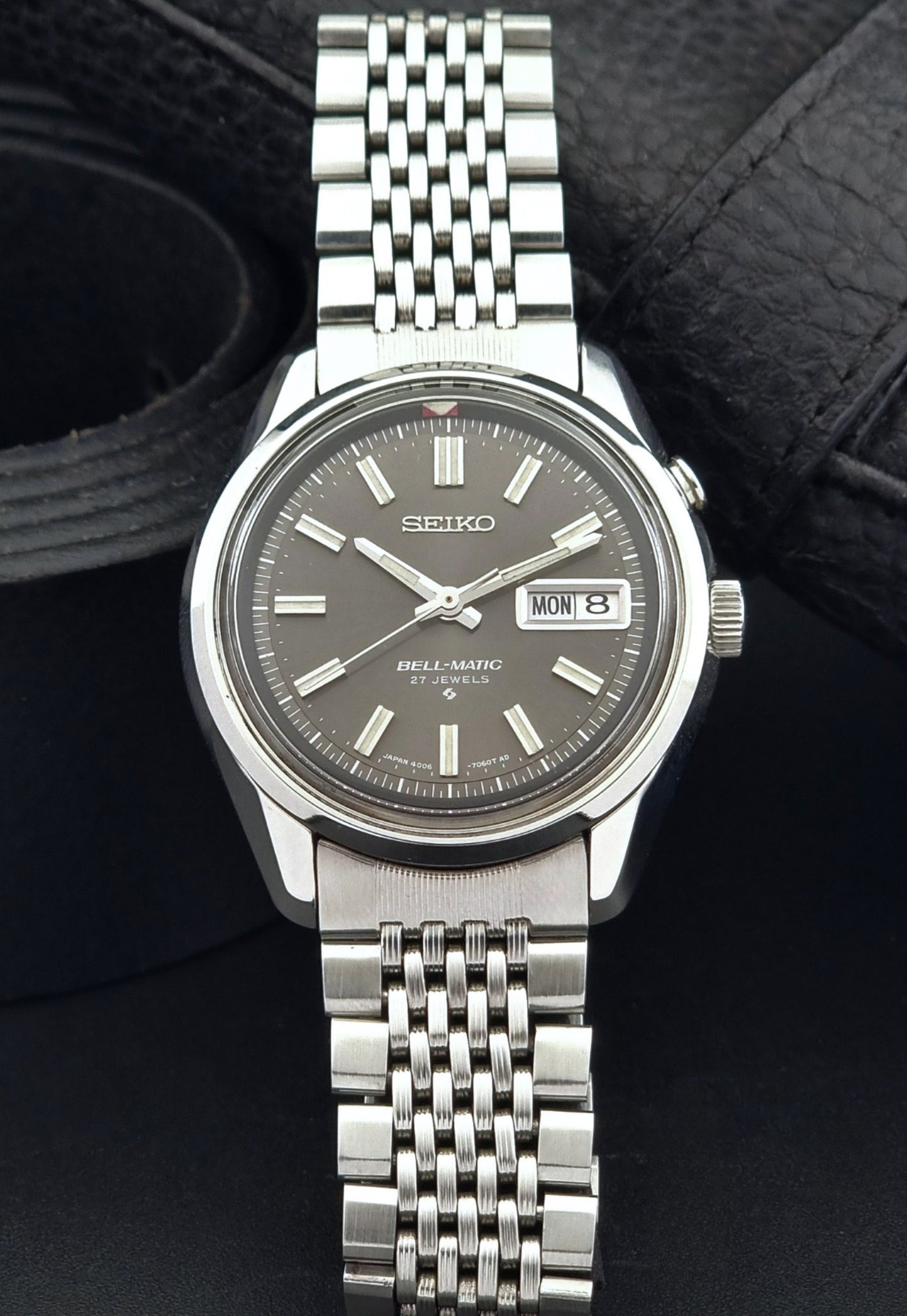 Vintage Seiko Alarm Watch Bell-Matic 4006-7010 with a dark face on a black background front view