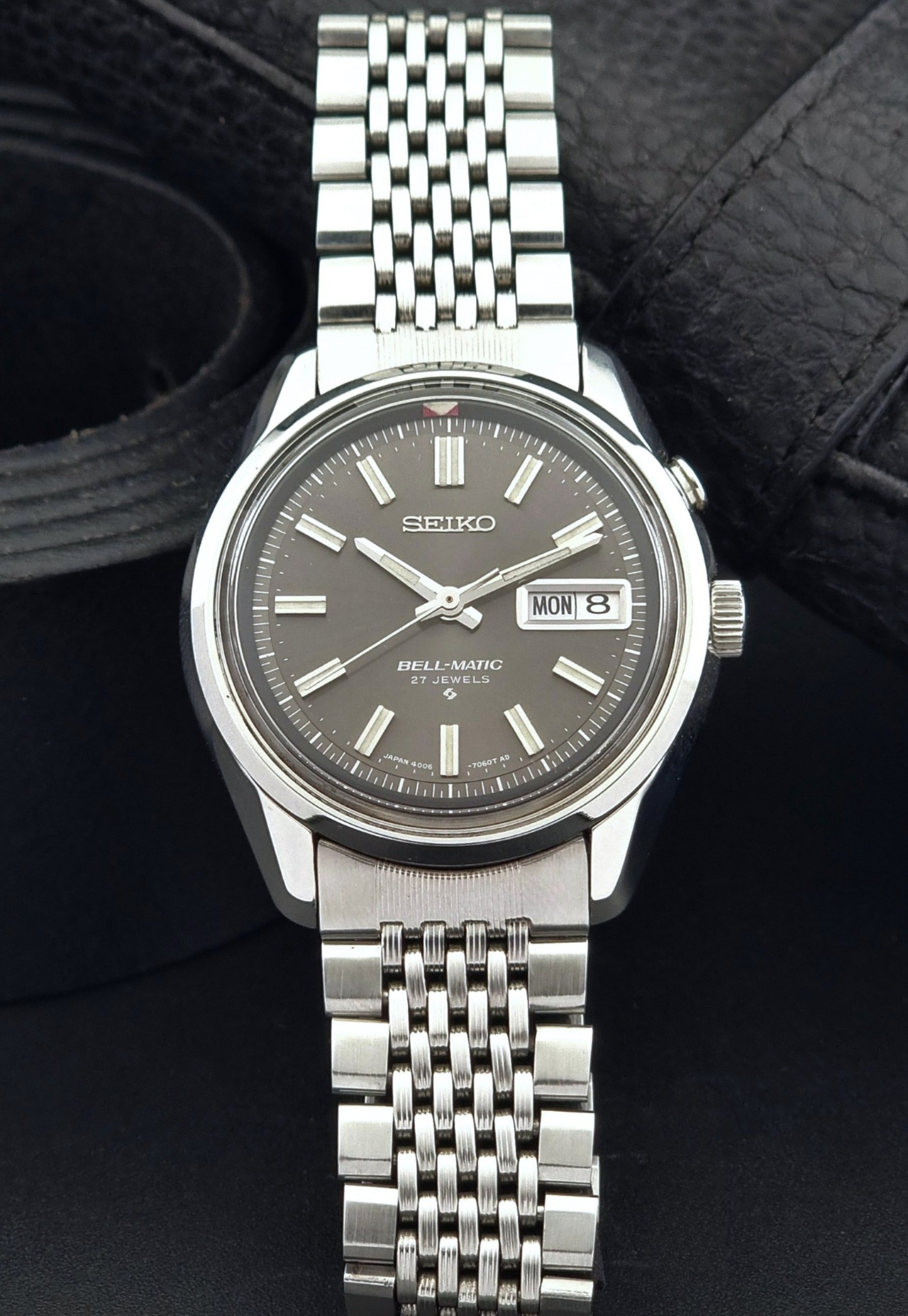 Vintage Seiko Alarm Watch Bell-Matic 4006-7010 with a dark face on a black background front view