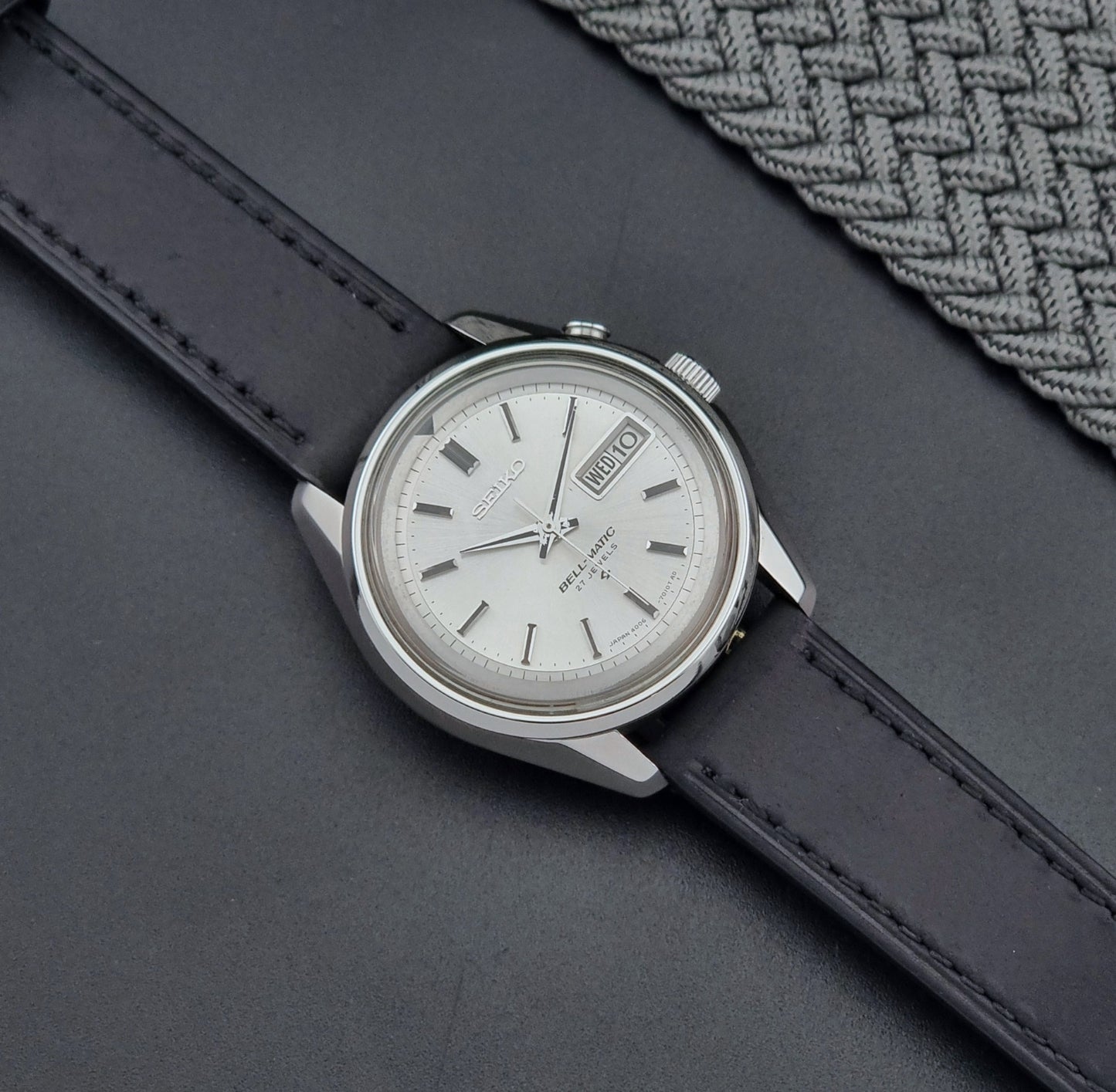 Vintage Seiko Alarm Wristwatch Bell-Matic 4006-7010 with black leather strap on a dark surface dial
