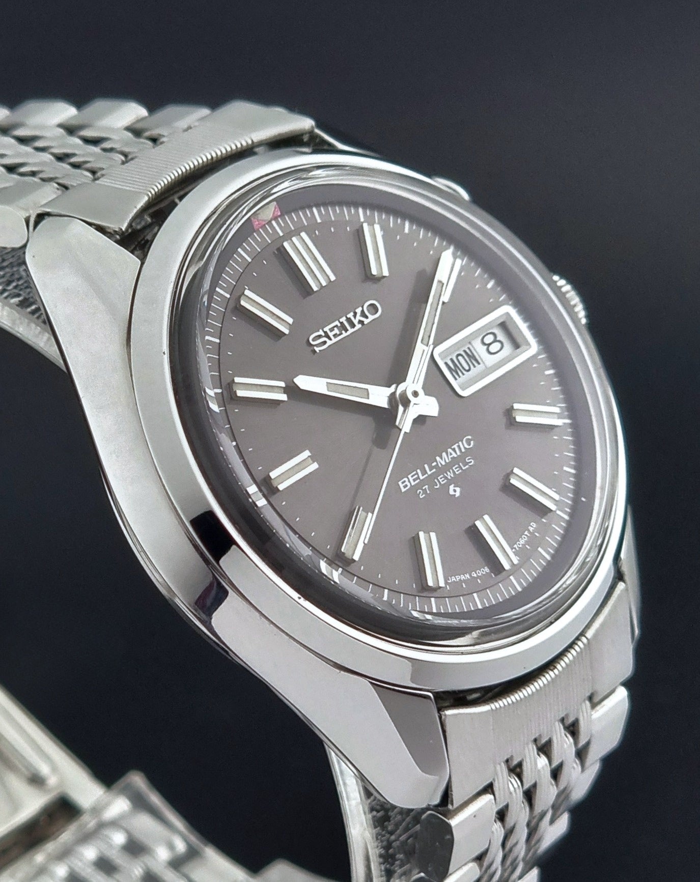 Vintage Seiko Alarm Watch Bell-Matic 4006-7010 with a dark face on a black background close side profile view