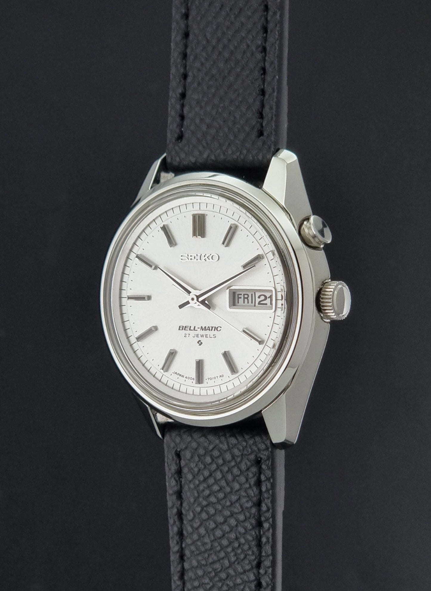 Vintage Seiko Alarm Wristwatch Bell-Matic 4006-7011 with a black strap on a dark background crown profile view