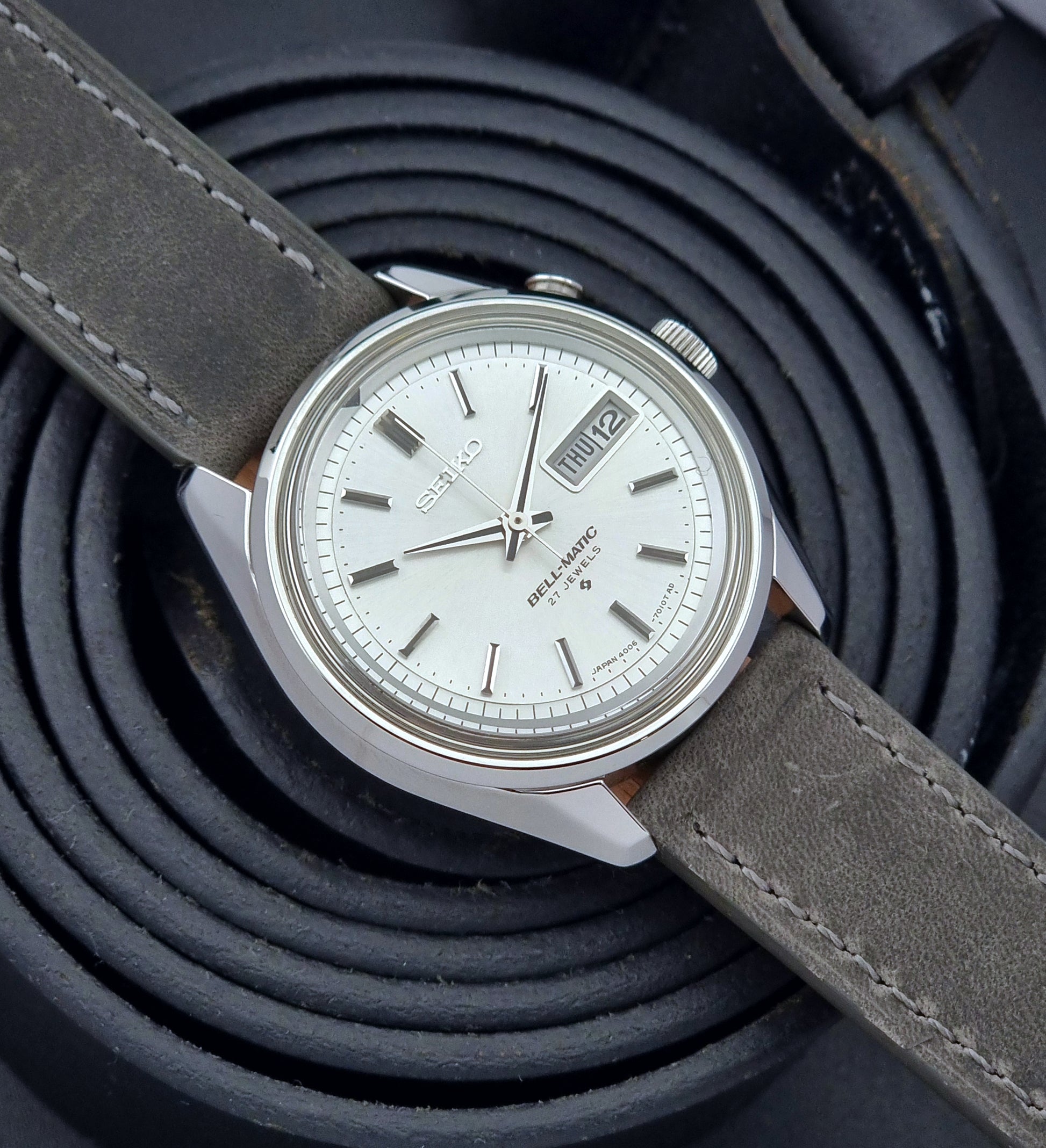 Vintage Seiko Alarm Wristwatch Bell-Matic 4006-7011 with a grey strap on a black background front