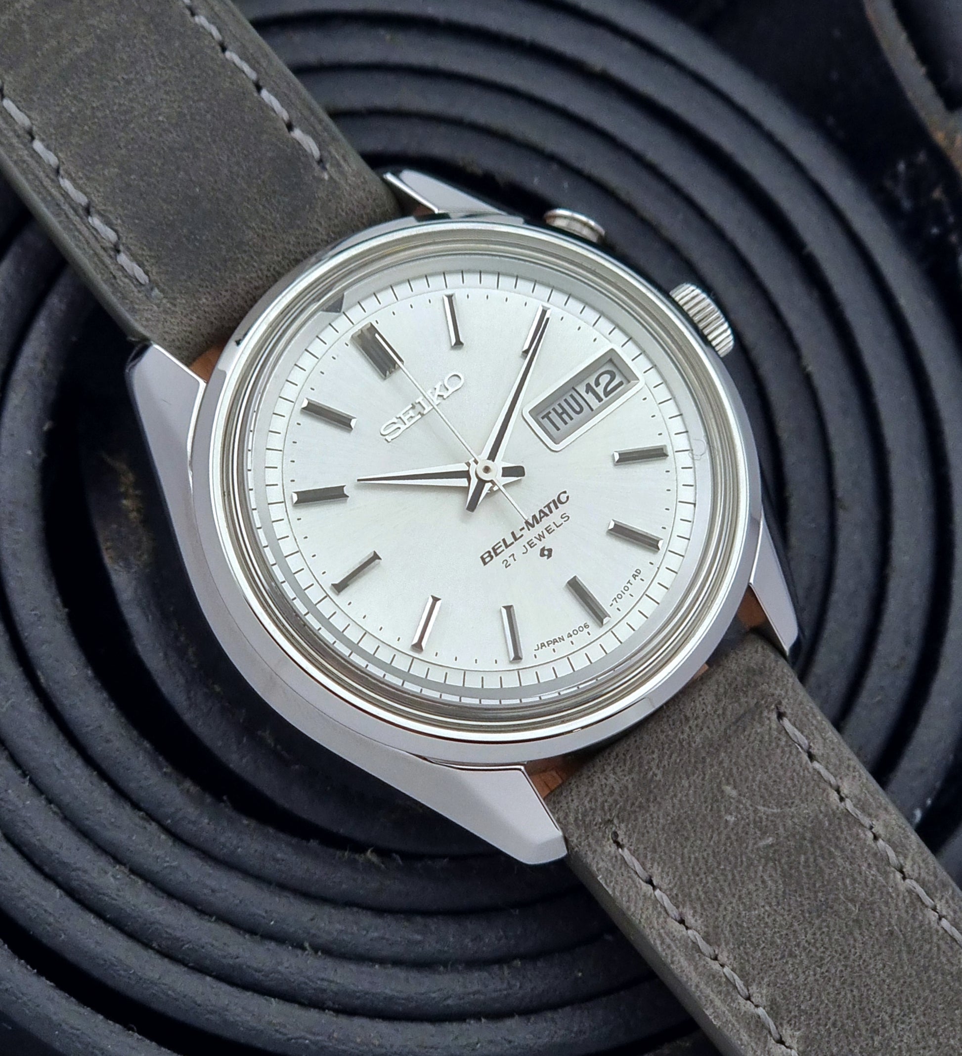 Vintage Seiko Alarm Wristwatch Bell-Matic 4006-7011 with a grey strap on a black background close dial view