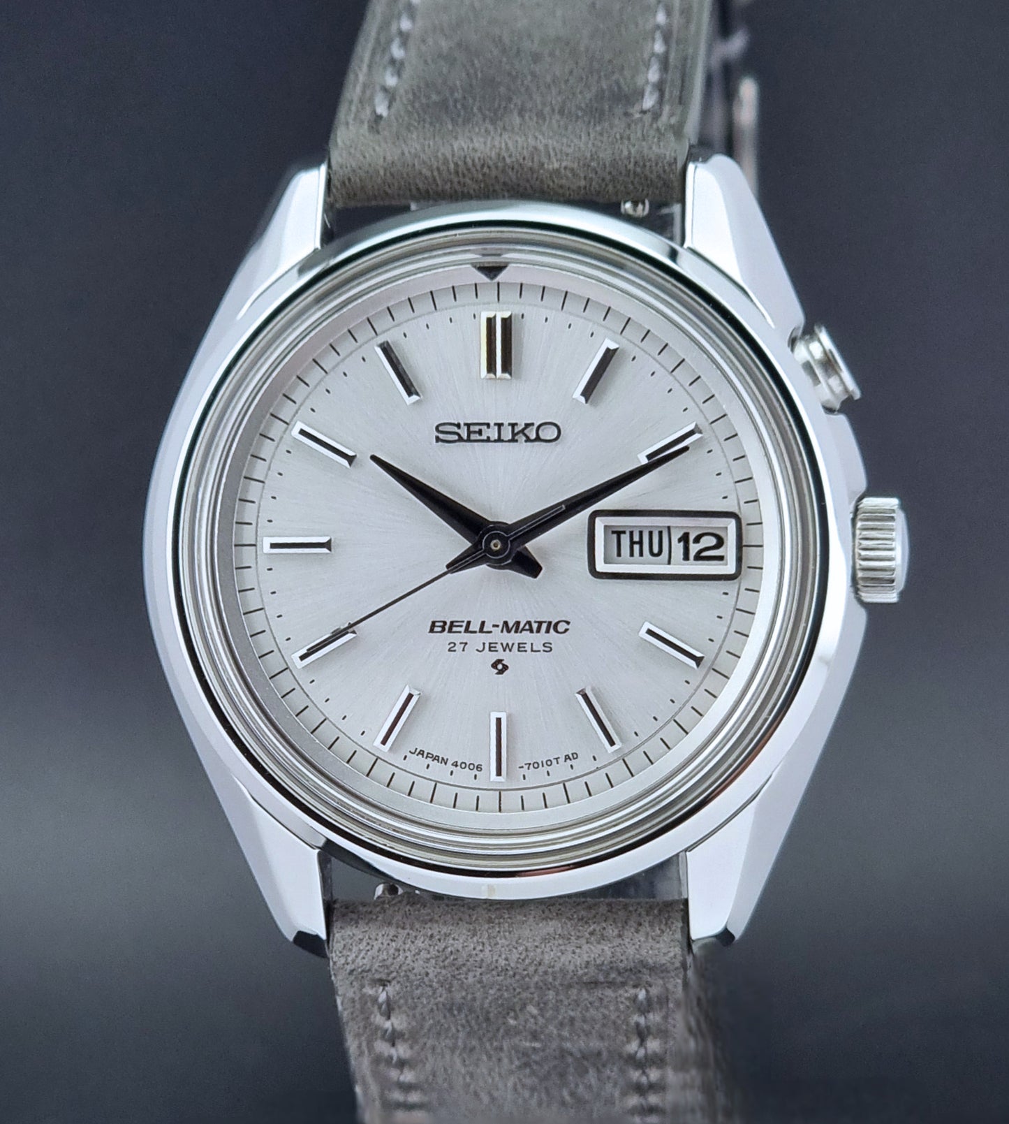 Vintage Seiko Alarm Wristwatch Bell-Matic 4006-7011 with a grey strap on a black background dial view