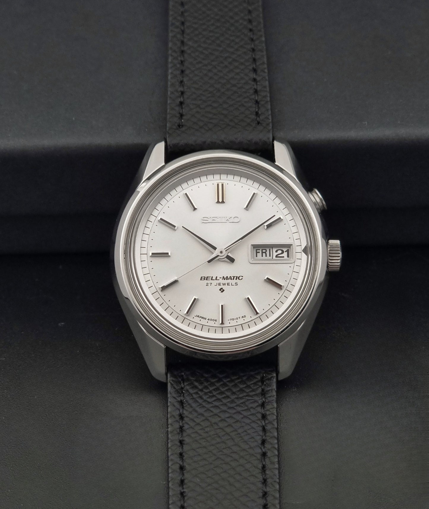 Vintage Seiko Alarm Wristwatch Bell-Matic 4006-7011 with a black strap on a dark background dial view
